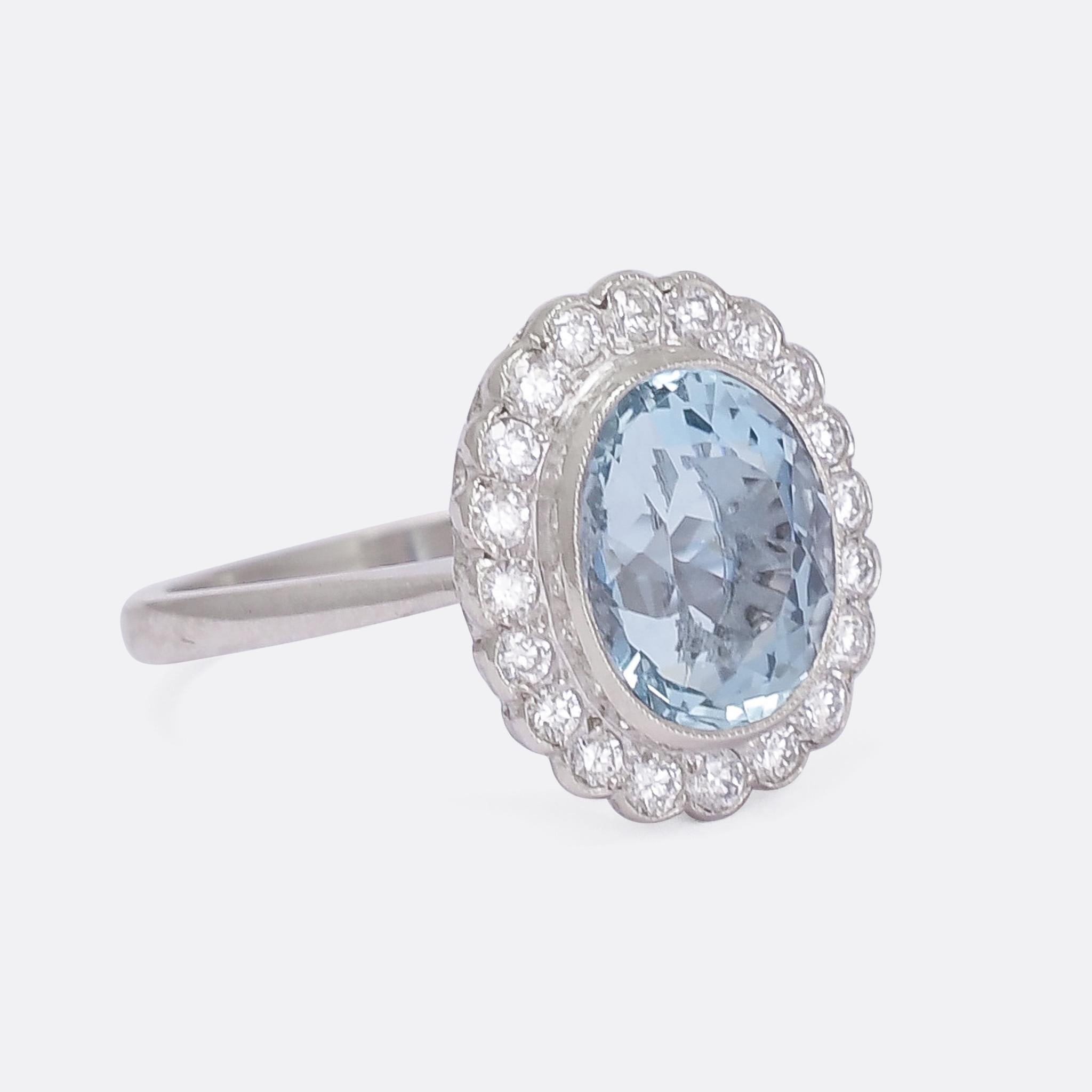 A stunning Art Deco period aquamarine and diamond flower cluster ring dating from the 1920s. Modelled in platinum throughout, it features millegrain bezel settings and gorgeous openwork behind the head allowing lots of light in behind the stones.