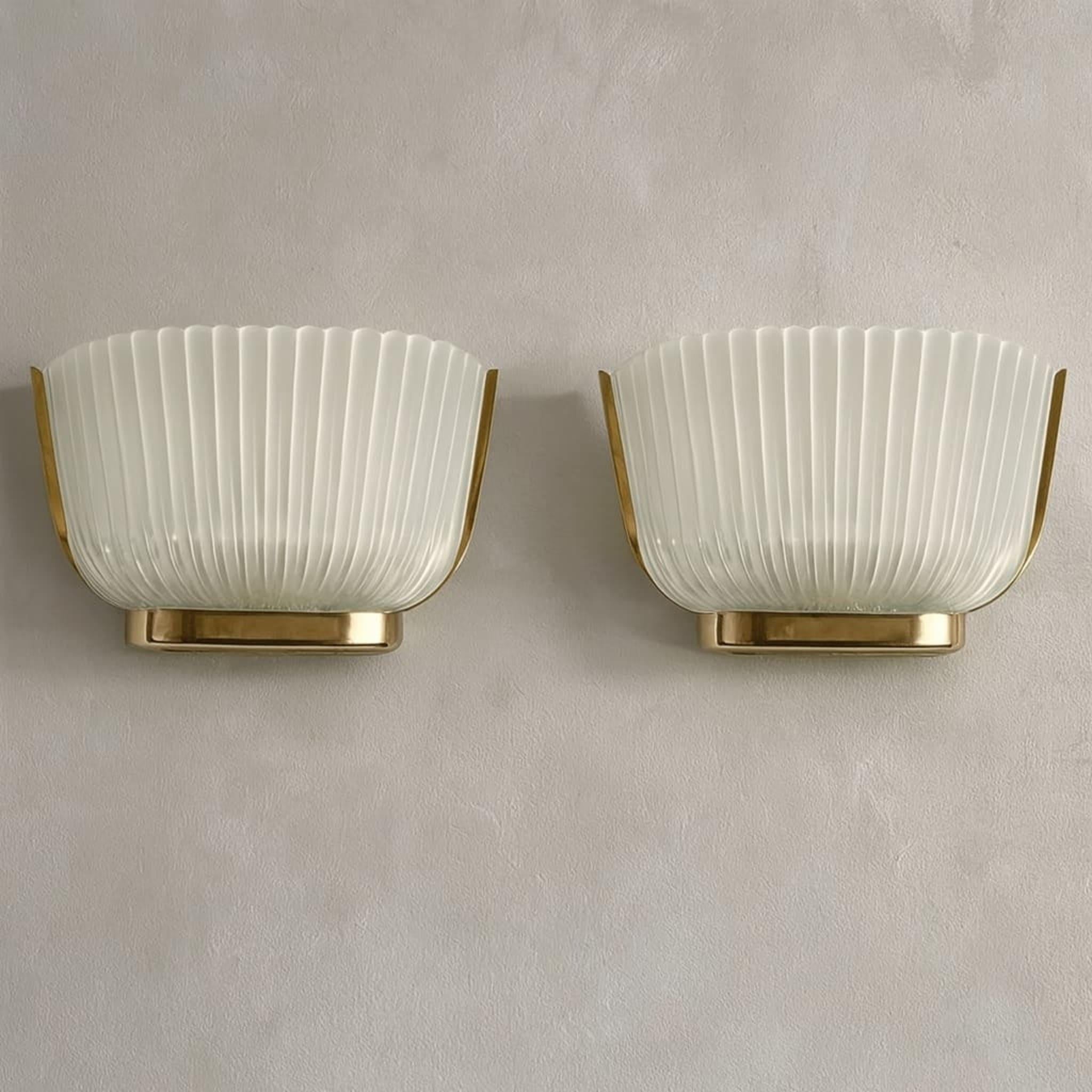 Elegante pareja de apliques de pared de inspiración Art Déco de Archimede Seguso, Italia, hacia 1940.
Cada candelabro tiene un marco de latón pulido que sostiene una pantalla de cristal de Murano finamente estriado, combinando claridad y textura en