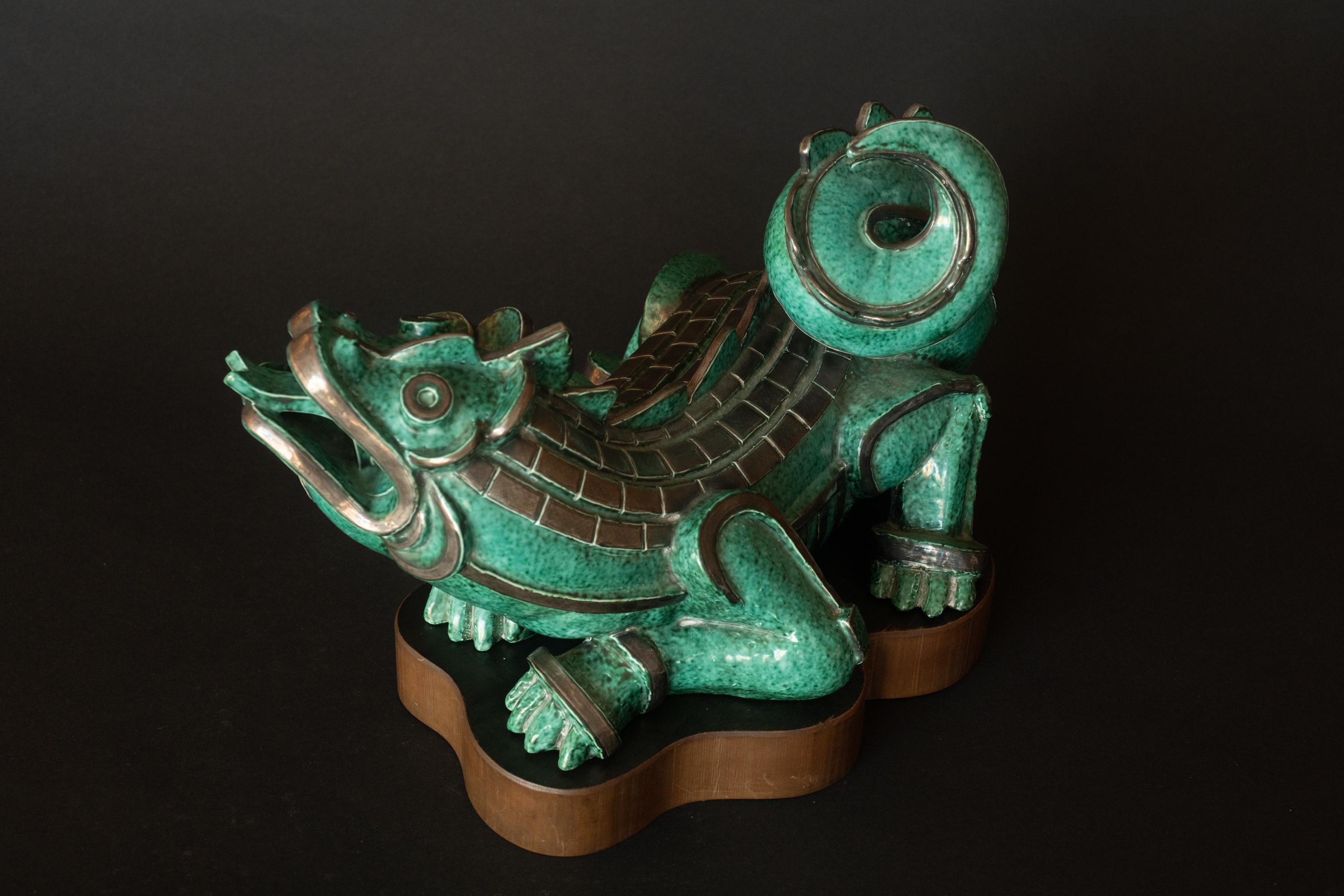 ARGENTA DRAGON, by Wilhelm Kåge (Swedish, 1889-1960), aqua green-glazed stoneware with sterling silver accents, mounted on a custom molded wood base, c. 1930, most likely an exhibition piece. 

The striking mottled aqua green glaze is an early