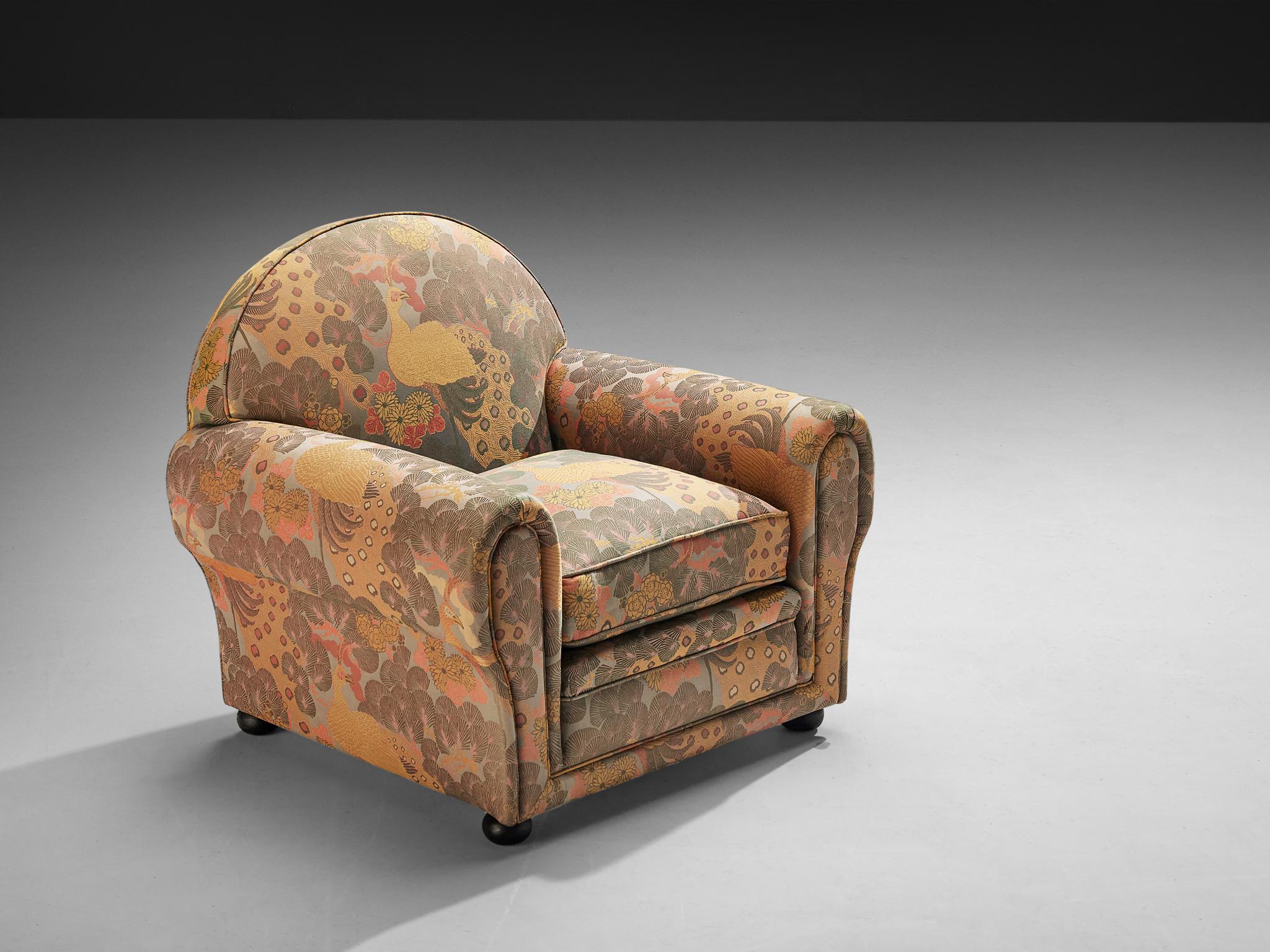 Armchair, fabric, dark stained beech, Italy, 1930s

This Italian armchair from the 1930s is upholstered in a richly patterned fabric featuring peacocks and botanical motifs. The warm hues and intricate details lend the piece a decorative yet refined