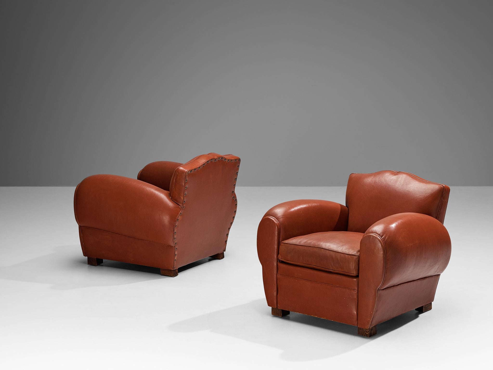 Maurice Rinck, pair of lounge chairs, reddish brown leather, beech, France, 1940s

Grand and comfortable set of two club chairs in leather upholstery. Truly extraordinary and luxurious chairs that feature a deep seat and large rounded, curved