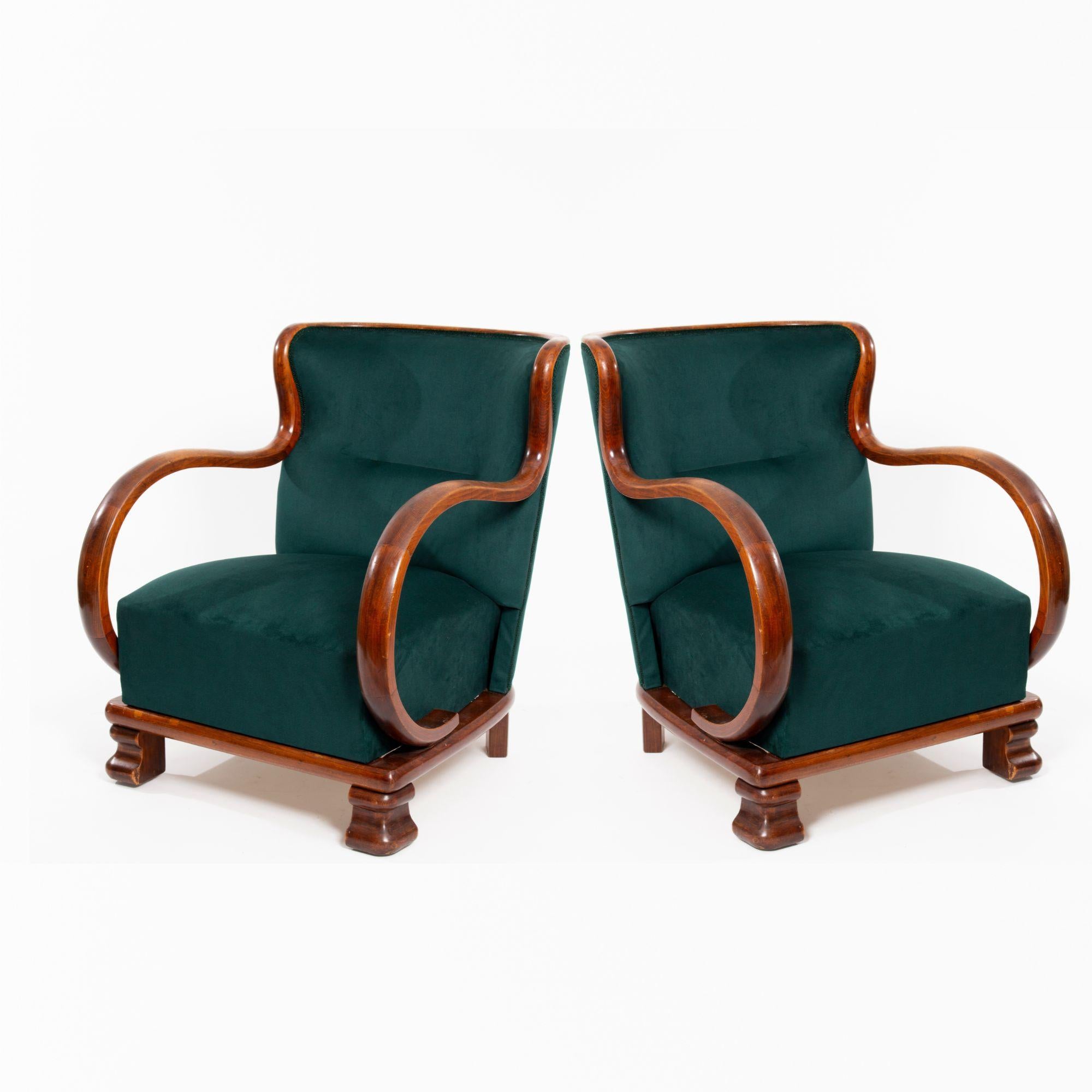 Two Art Deco armchairs, beautifully reupholstered in luxurious green velvet. These elegant pieces feature gracefully curved armrests, adding a touch of sophistication to any room. The wood frames are in good condition. These decorative armchairs are