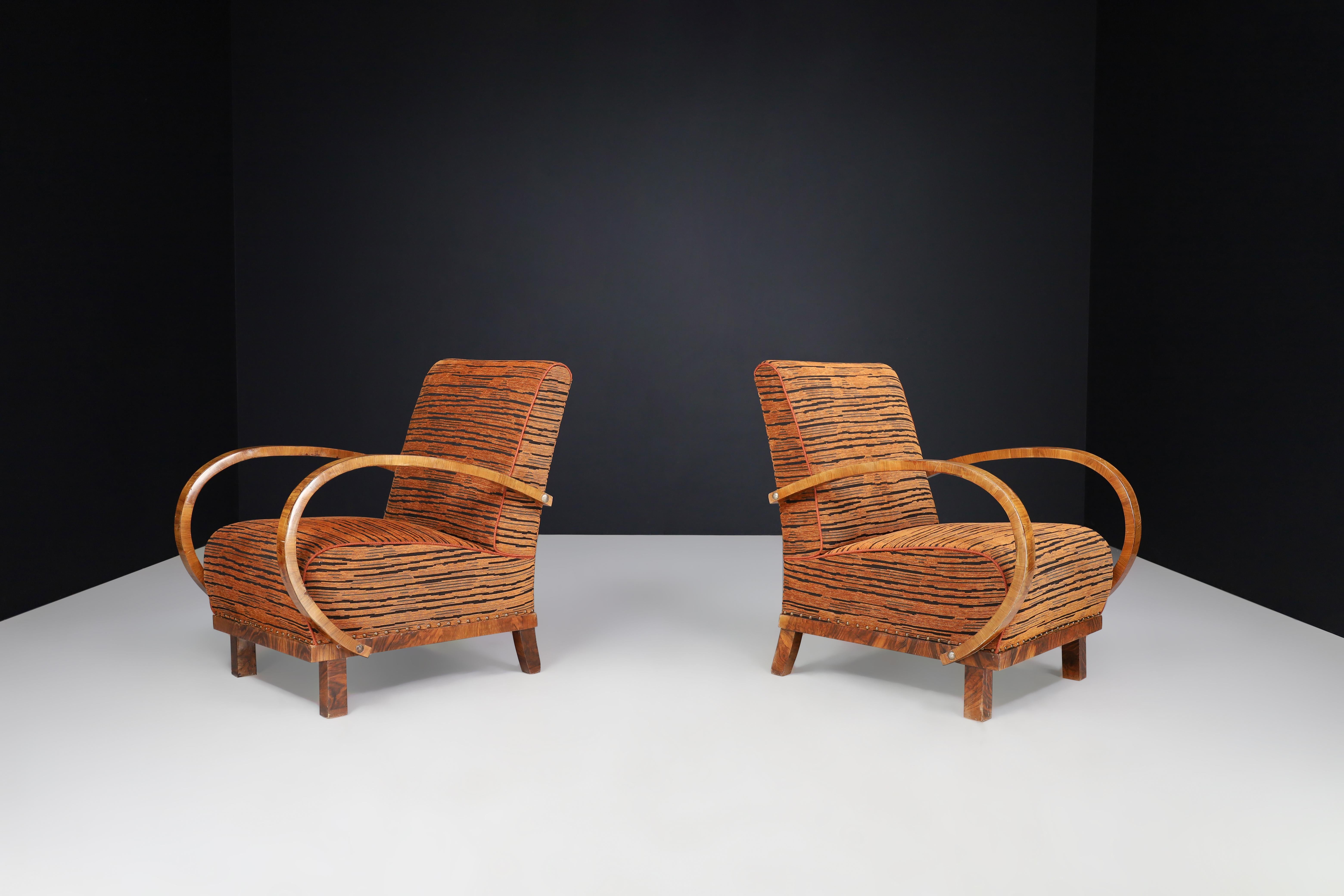 Art Deco armchairs in walnut in new upholstery, Austria 1930s

These are two Art Deco armchairs or lounge chairs made from walnut and upholstered with new fabric. They were made in Austria in the 1930s. These low armchairs are a great addition to
