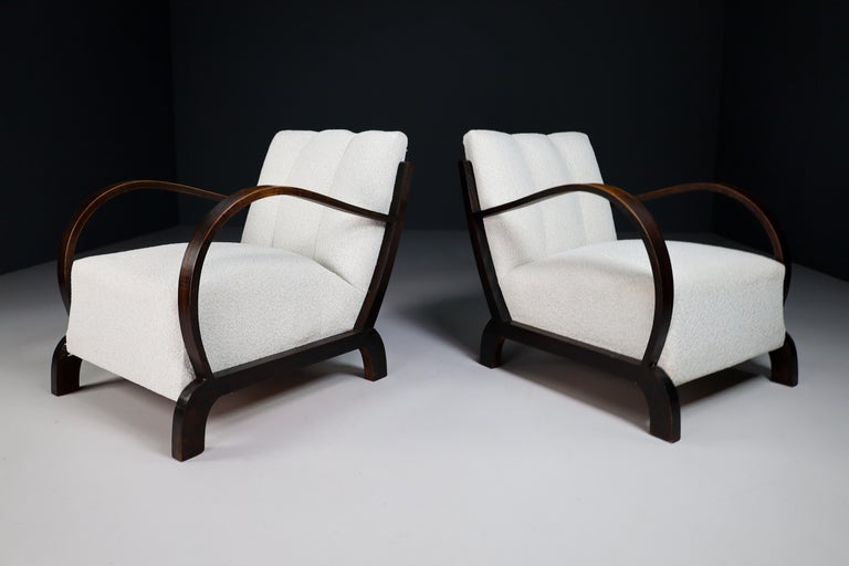 Pair of two elegant Art-Deco armchairs or lounge chairs manufactured and designed in Vienna 1930s. Made of hardwood and professionally reupholstered in bouclé wool fabric. These armchairs would make an eye-catching addition to any interior such as