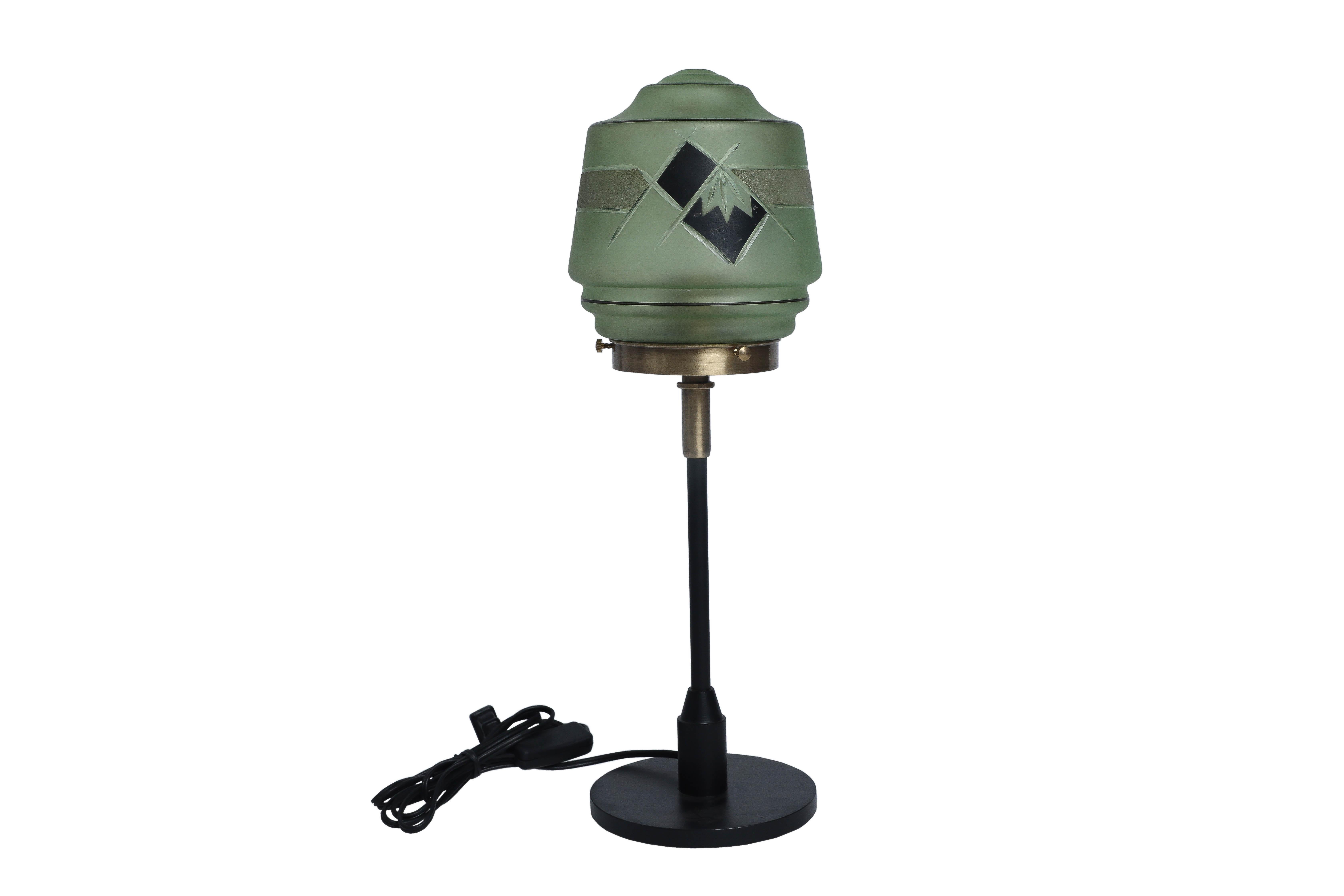 Une superbe paire d'abat-jour en verre d'art vert pâle et noir de la période Art déco. Montée sur une paire de lampes de table en fer et en laiton. Recâblée pour une utilisation américaine, elle est dotée d'une ampoule à culot standard. Européen.