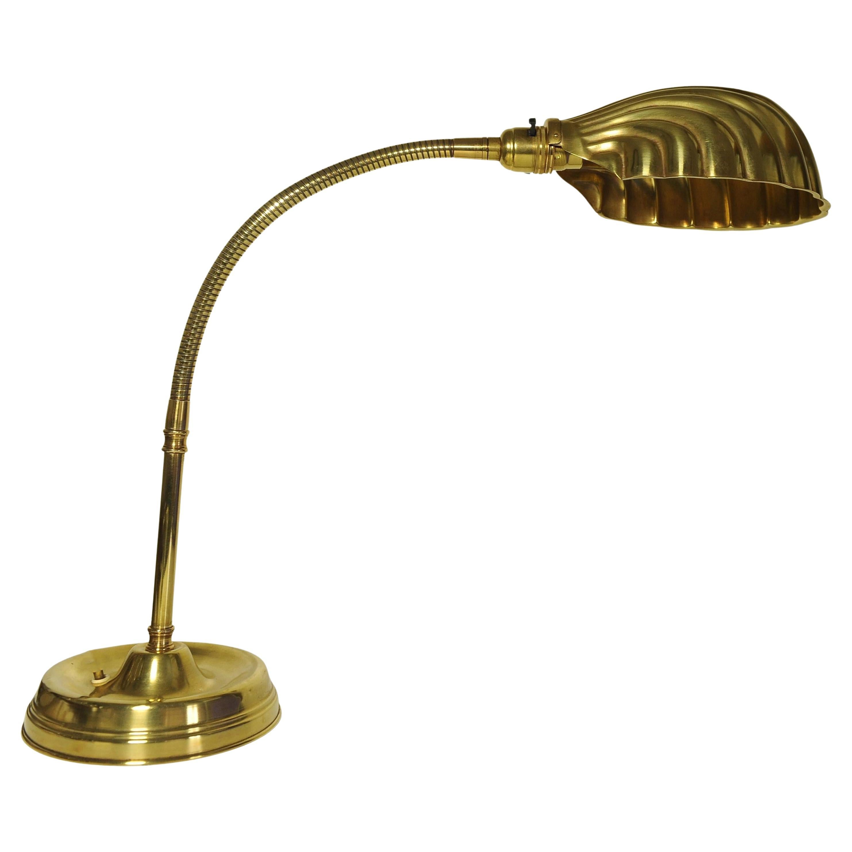 Early 20th century Art Deco articulated brass gooseneck desk lamp with decorated Brassed Copper Shell Shaped Shade on a circular brass weighted base 1920s.