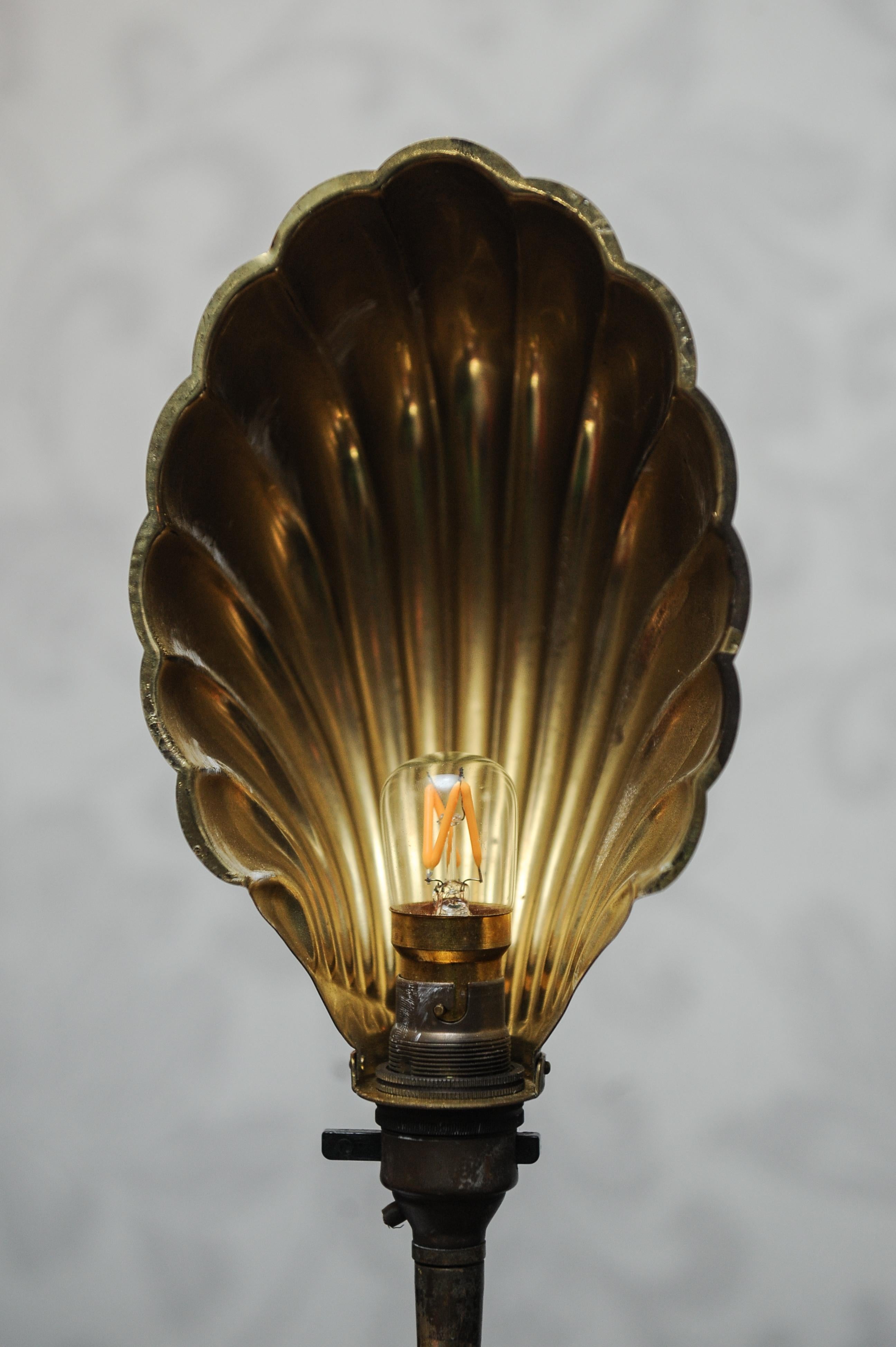 Early 20th century Art Deco articulated brass gooseneck desk lamp with decorated Brassed Copper Shell Shaped Shade on a circular brass weighted base 1920s.