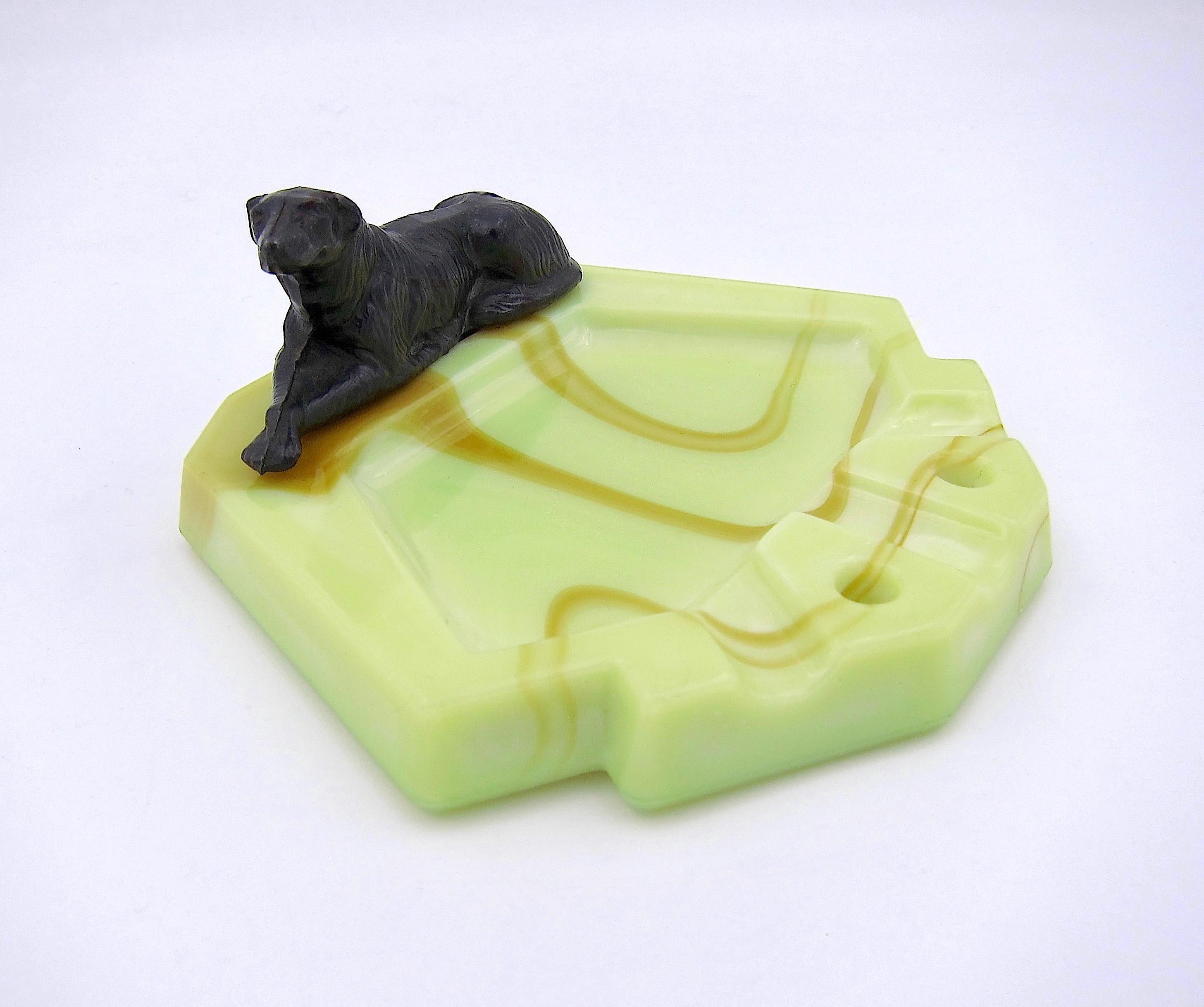 An Art Deco catchall dish or ashtray in marbleized pale green glass with butterscotch swirl accents and a spelter metal sculpture of a Borzoi / Russian Wolfhound mounted at the edge. Unmarked but manufactured by L.J. Houze Convex Glass of Point