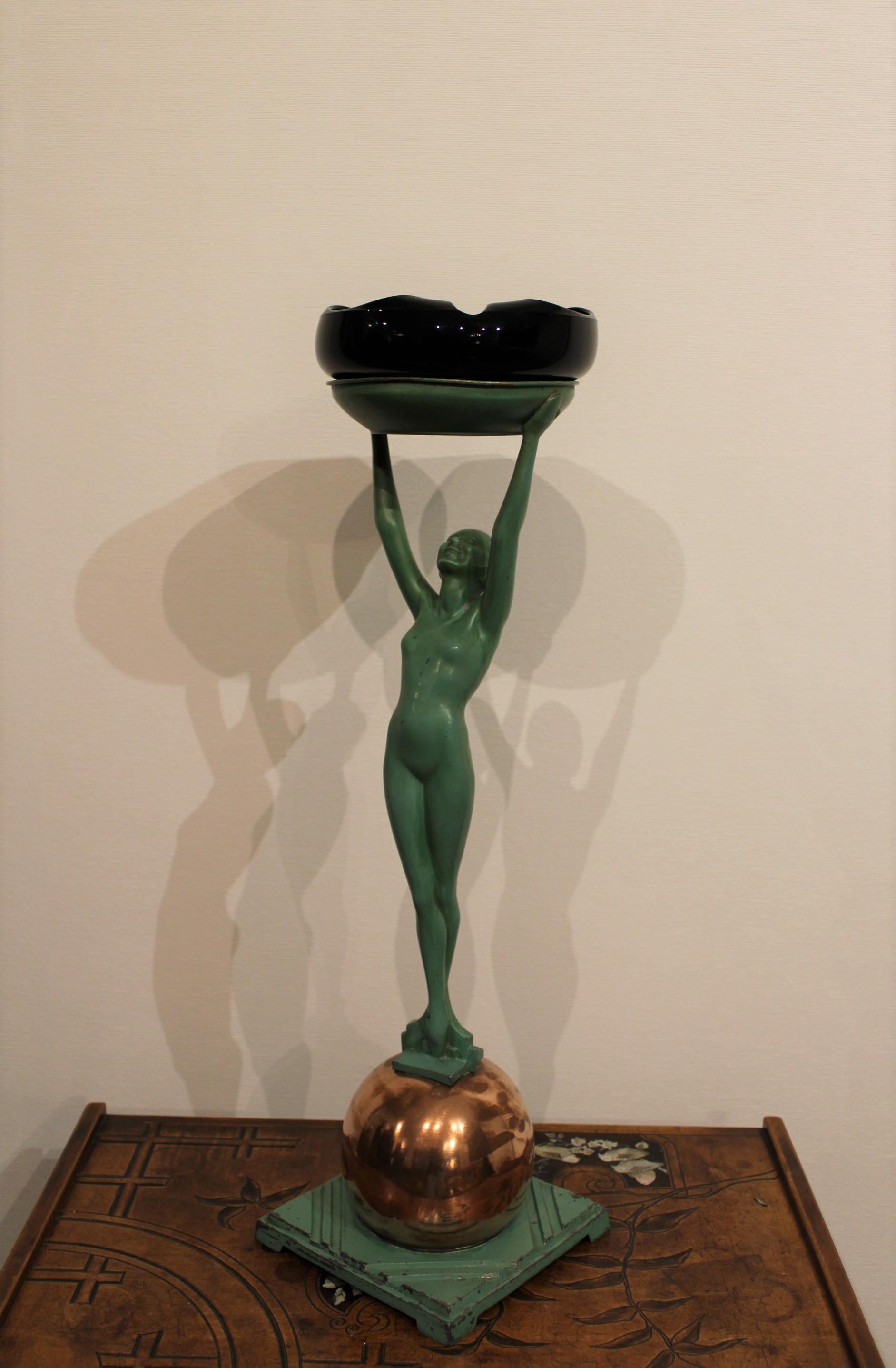 Art Deco sculpture in metal.
Black ashtray in glass, signed below.

Wears and crack on the belly of the character (see photos details).
 