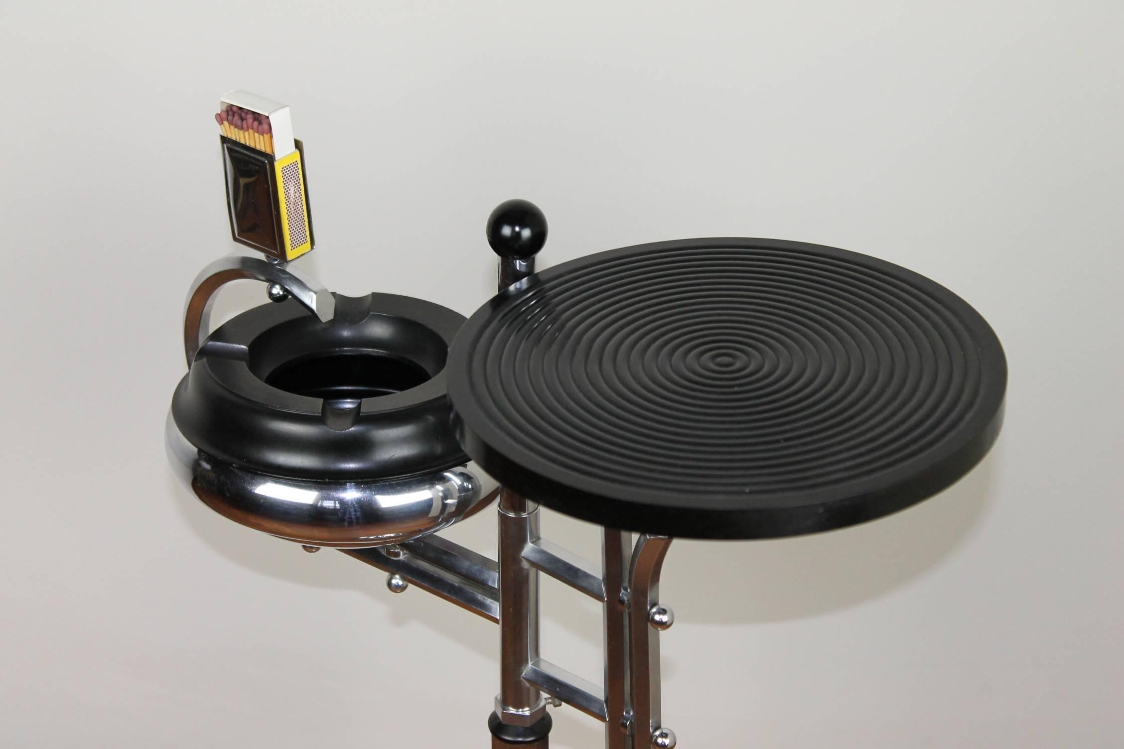 Support de cendrier:: support de fumée:: cendrier sur pied:: cendrier de sol. 
Ce cendrier Art Déco sur atand avec une tablette pour boisson est fabriqué en chrome et bakélite et le dessus (cendrier et tablette) peut être retourné. 
Il a été