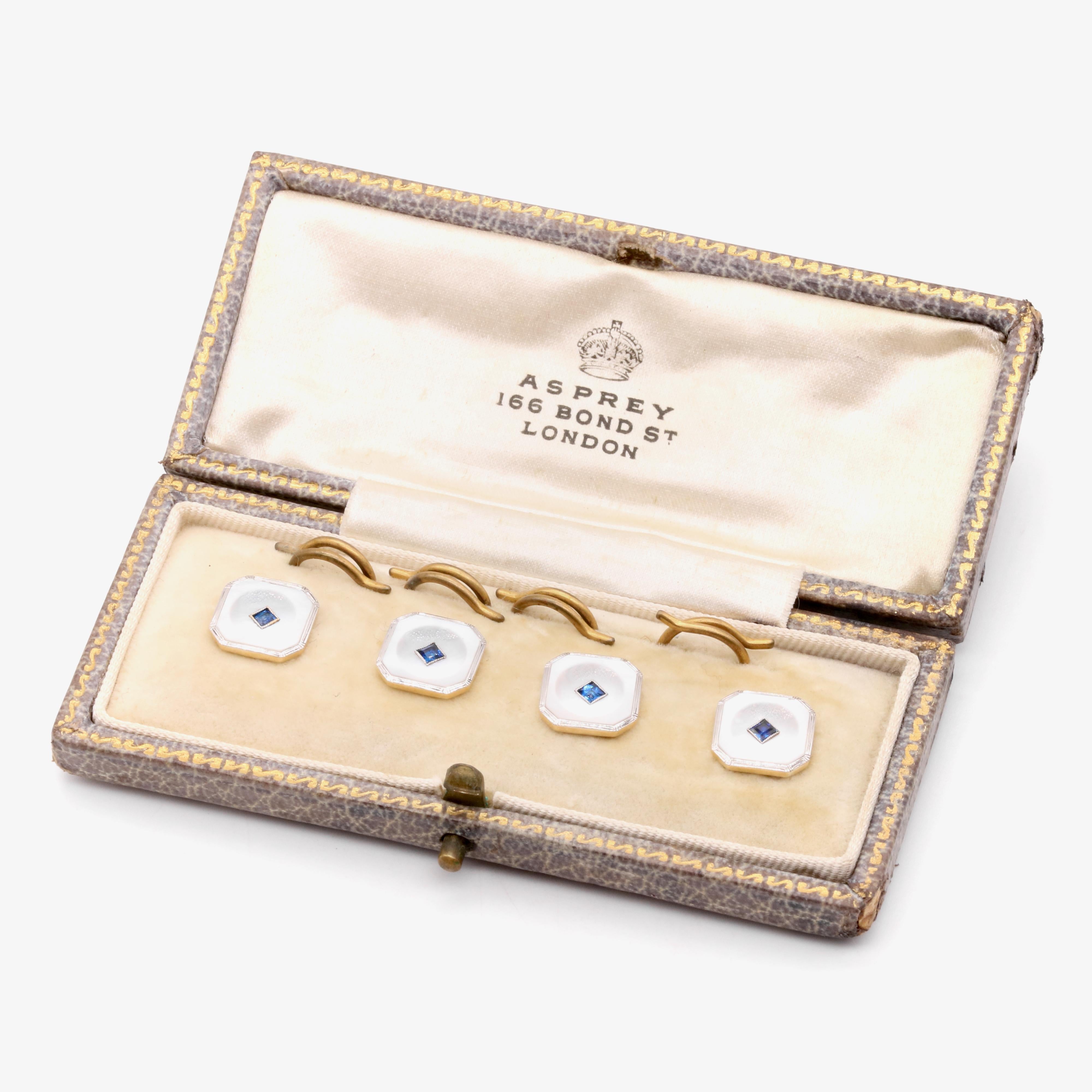 An Art Deco set of sapphire, mother of pearl, platinum, and yellow gold dress studs, each comprising one square cut sapphire, and one panel of mother of pearl, set in platinum, backed in 18 karat yellow gold. 

The dress studs are octagonal in