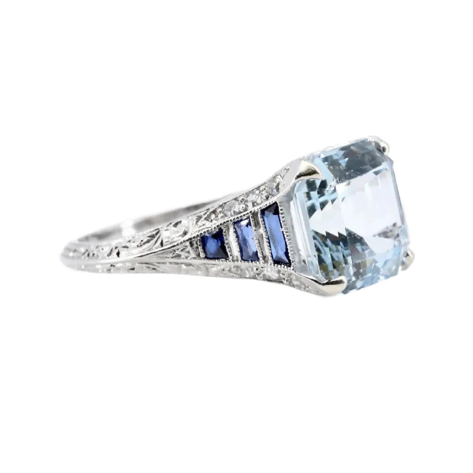 A striking Art Deco period Aquamarine, Sapphire, and Diamond ring in platinum.

Centered by a 3.40 carat Asscher cut Santa Maria aquamarine secured by four claw form prongs.

Framed by six vivid blue trapezoid shaped French cut sapphires, cut to