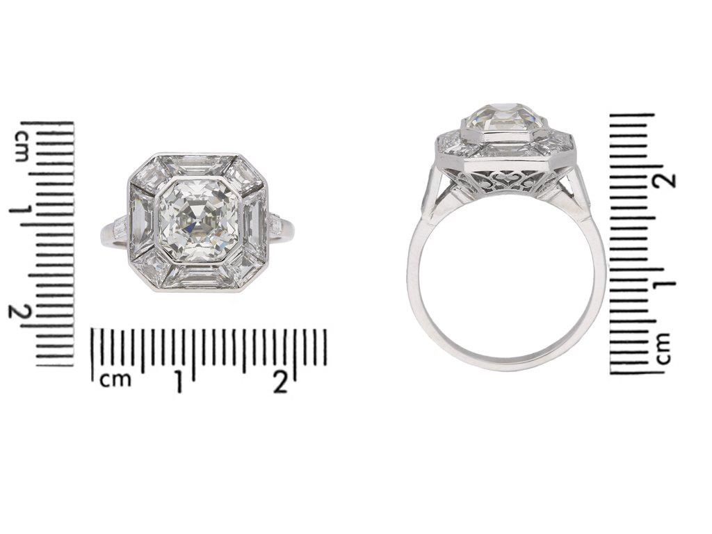 Art Deco Asscher cut diamond cluster ring. Centrally set with an octagonal Asscher cut diamond, J colour, VS1 clarity with a weight of 2.60 carats, in an open back rubover setting, surrounded and flanked by ten calibre step cut diamonds, G colour,