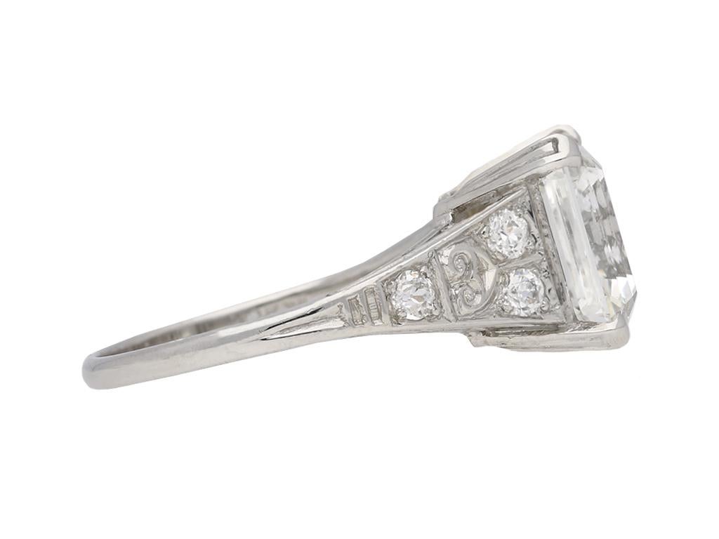 Art Deco Asscher cut diamond ring. Set to centre with one central octagonal asscher cut diamond, I colour, VVS2 clarity, in an open back corner claw setting with a weight of 4.51 carats, flanked by six round old cut diamonds in open back grain