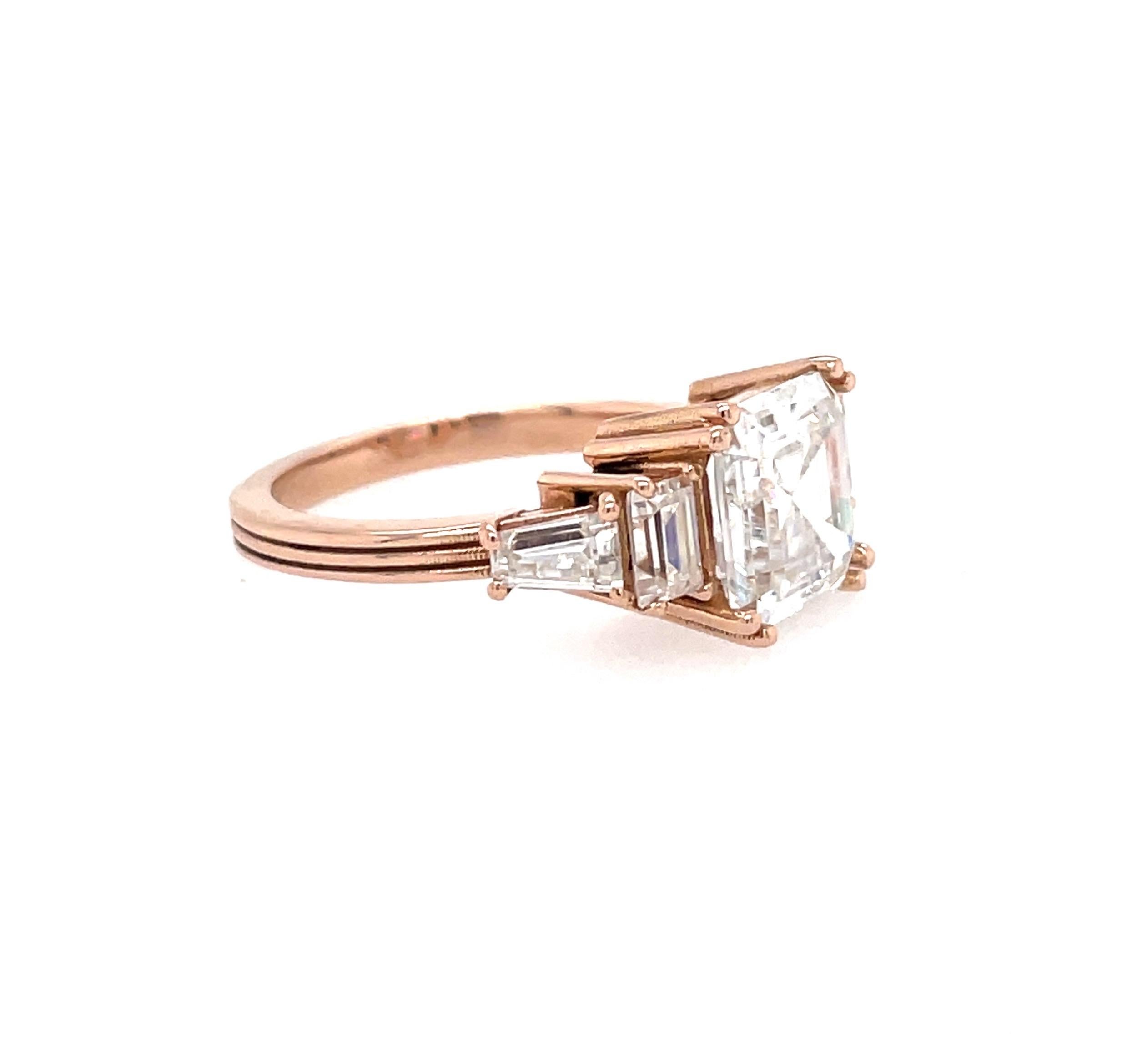 This Art Deco inspired Asscher cut engagement ring features a 2.20ct Forever One moissanite with eagle claw prongs, accented by sparkling 1.00ct custom cut moissanite baguettes. The eagle claw prongs keep the unique square shape of the Asscher,