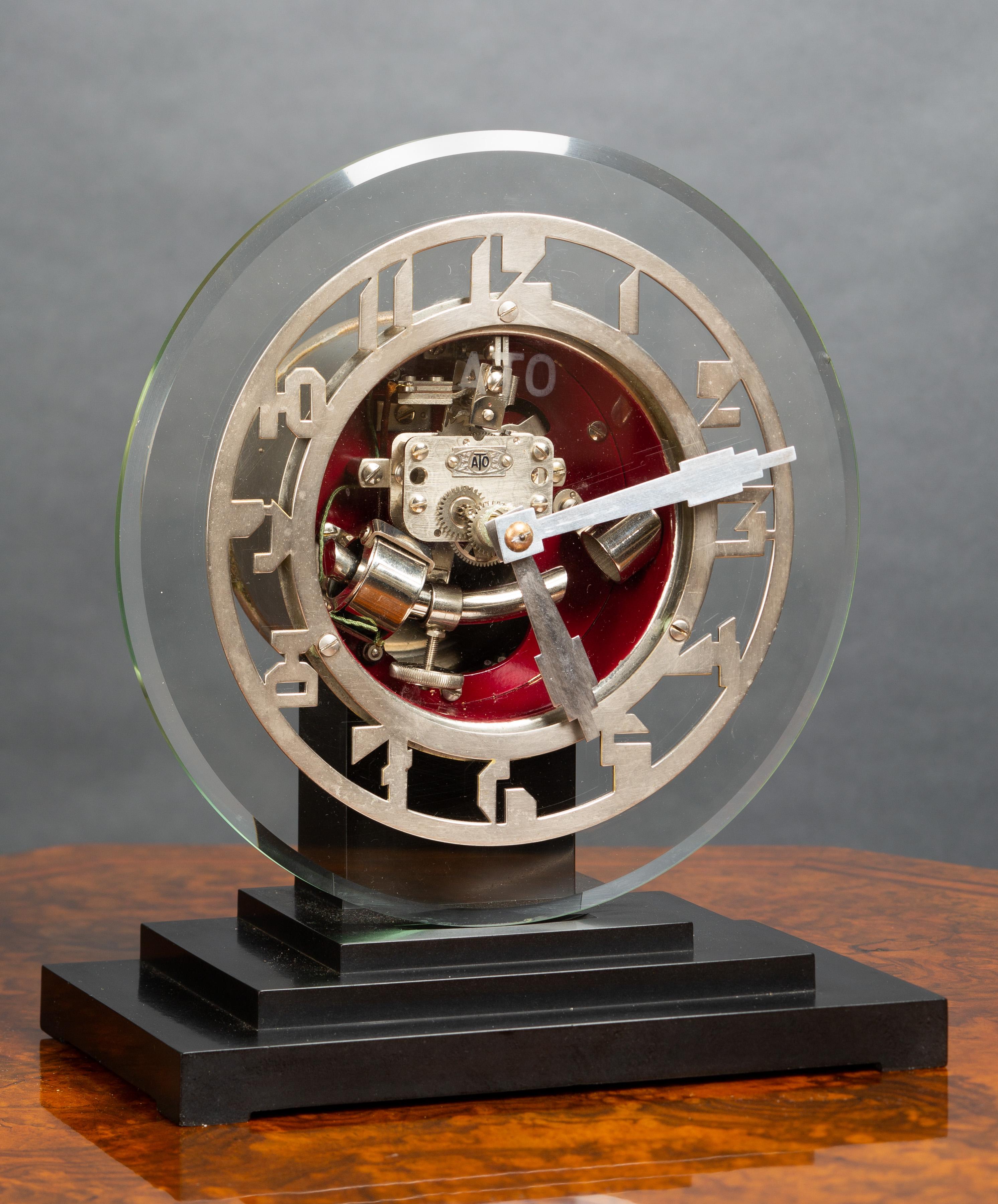 Art deco ATO clock standing on a three tiered Bakelite base supporting a glass dial with Art Deco style chrome numerals and chrome chapter ring.


The movement is powered by a 1.5 volt battery, the curved bar on the pendulum is a hollow rod