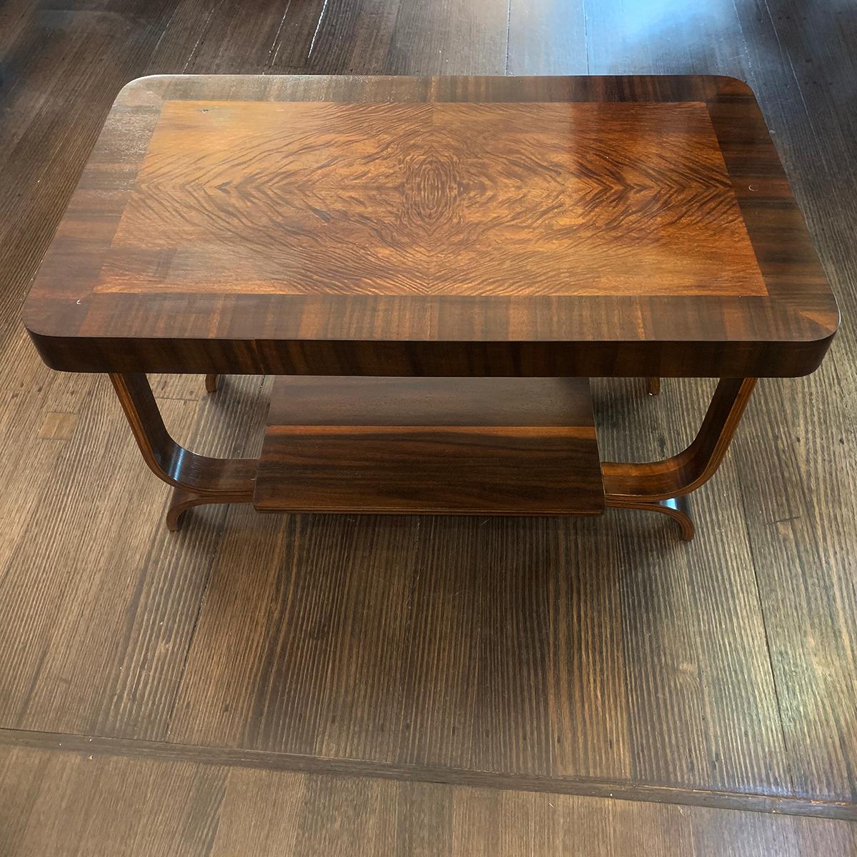 Art Deco coffee table with spectacular inlaid top and bentwood legs and supports, with lower shelf for magazines, etc. The upper inlay is 360 degree symmetrical with intensive grain detail, meeting at the quarter points. The lower shelf has also