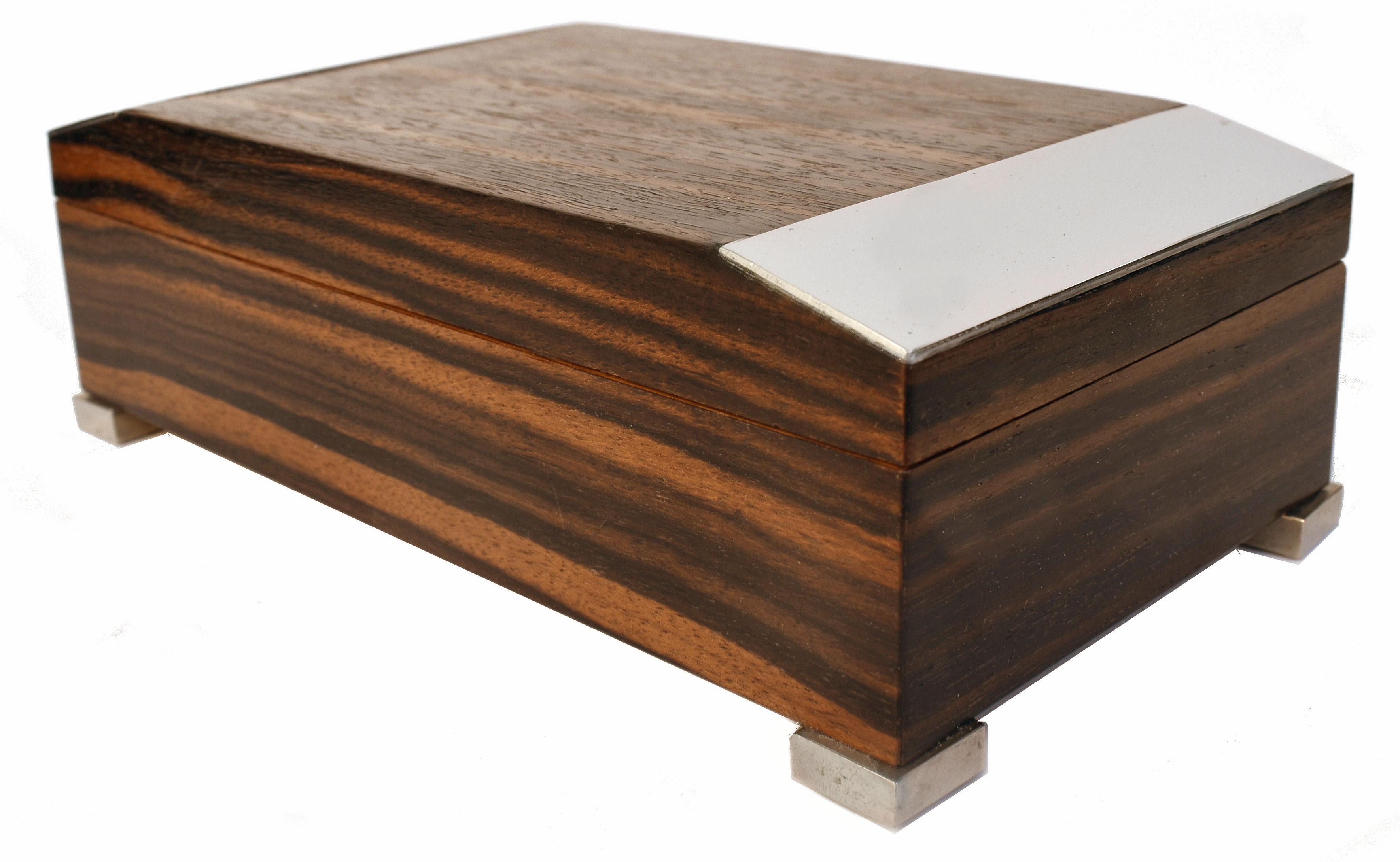 For your consideration is this very stylish and original Art Deco period Austrian wooden cigarette box finished in a Macassar Ebony veneer with chromed mounts : the box of rectangular form on square chromed feet, the canted lid with chromed edge