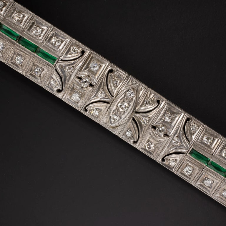 This absolutely unique diamond and emerald tennis bracelet is elegantly designed with artful, geometric touches and was masterfully crafted by hand a lifetime in the past during the illustrious Art Deco era. The bracelet features french cut emeralds