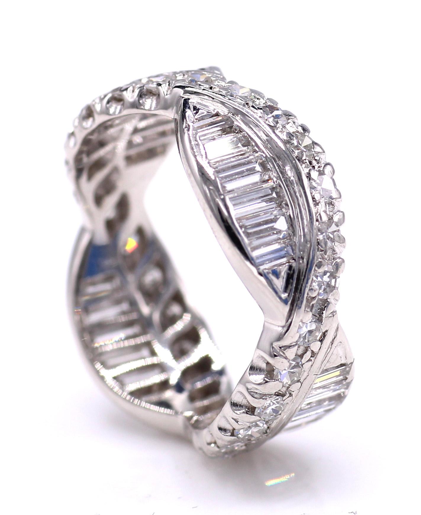 This unique Art Deco platinum diamond eternity band has been beautifully designed with a curving band of bright white round diamonds intersected with sections of equally white lively baguette cut diamonds. Masterfully handcrafted the perfectly