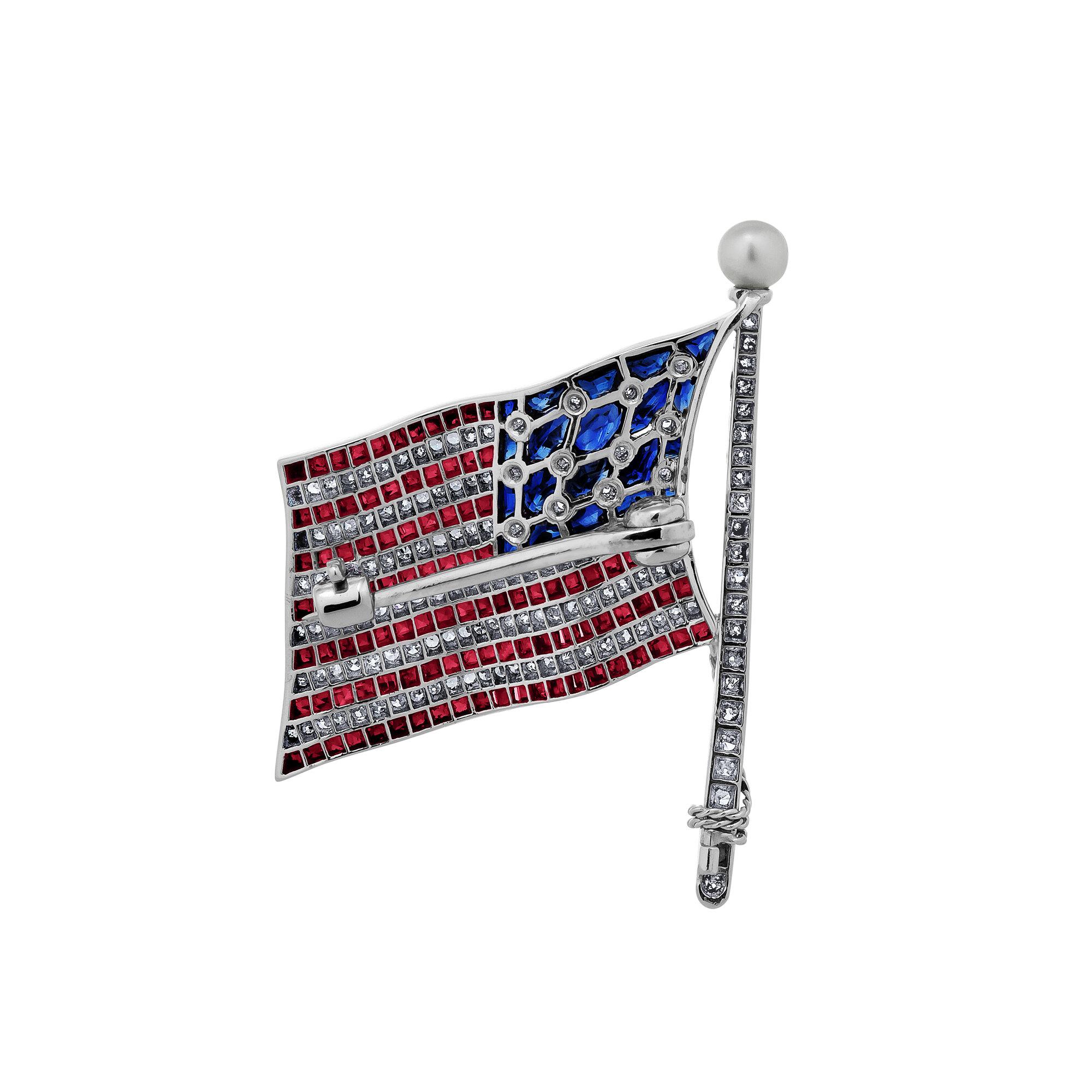 The American flag sparkles and shines with diamonds, rubies, and sapphires in this incredible Art Deco Bailey Banks & Biddle brooch.  Unfurling in a platinum mounting, our treasured red, white, and blue is topped with a natural pearl and is that