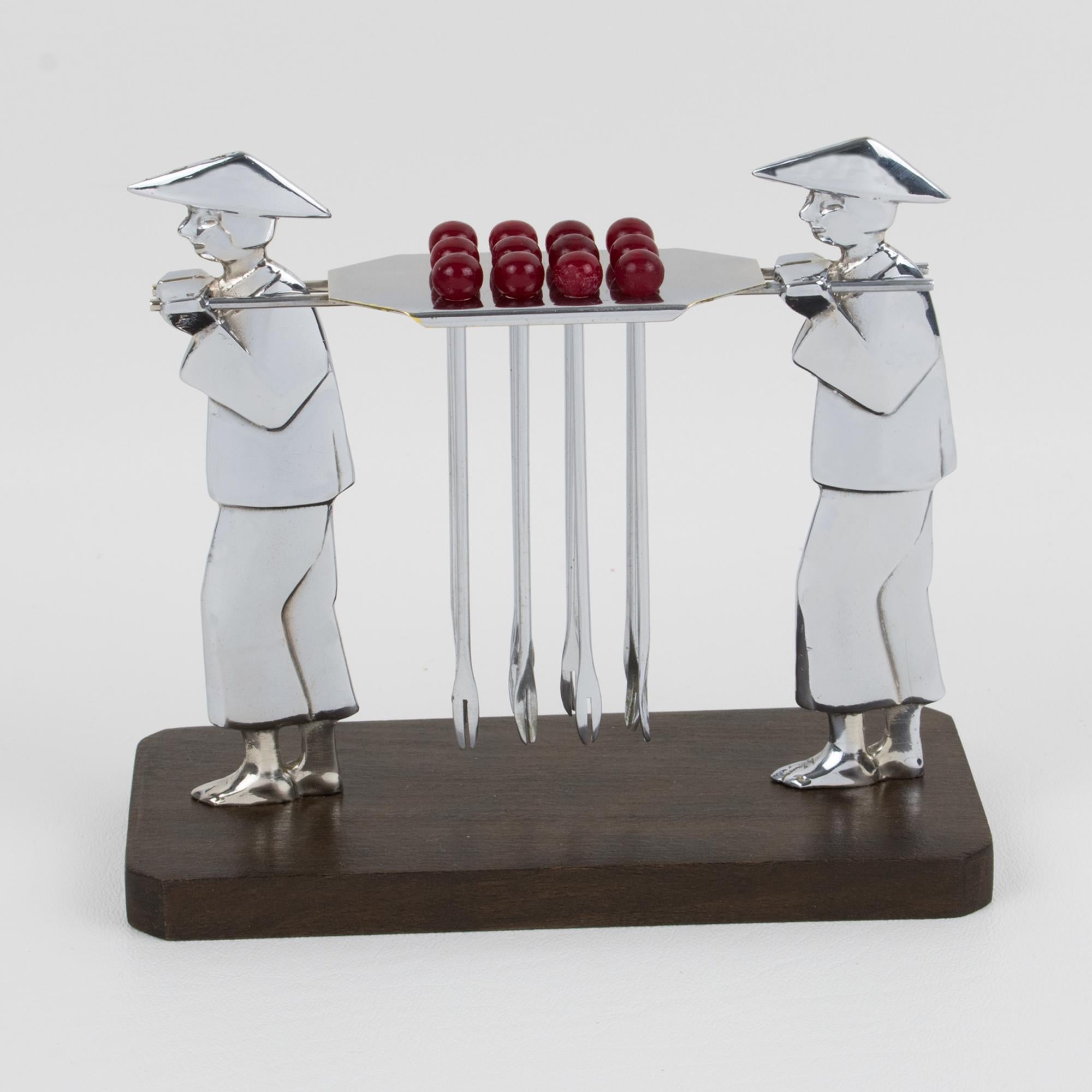Ce pic à cocktail exquis est composé de deux supports en métal chromé sculpté et d'un support central. Cette pièce rare a été fabriquée en France vers 1930. Douze fourchettes à cocktail en métal avec des embouts en bakélite rouge reposent sur le