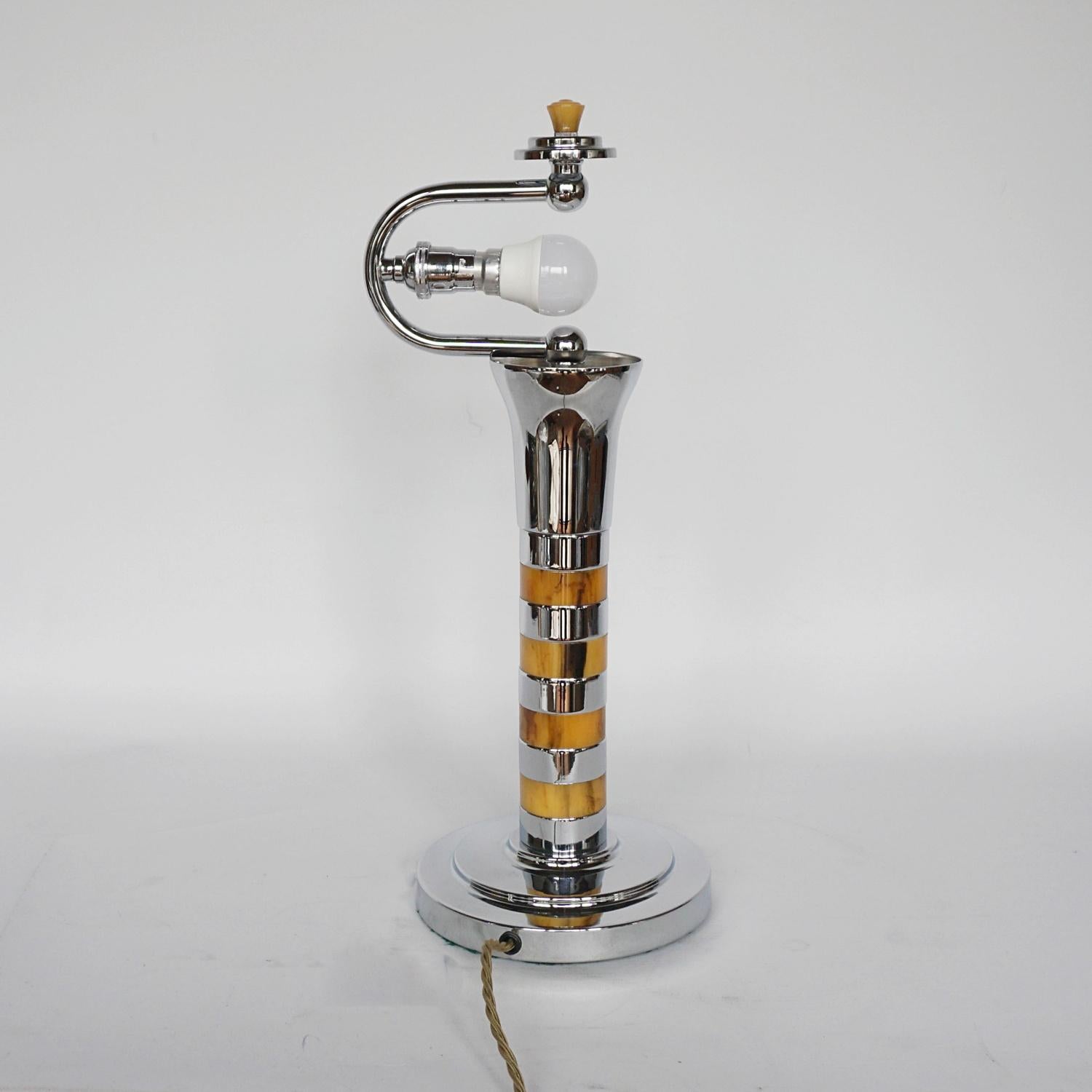 An Art Deco dome lamp. Bakelite and chromed metal banded stem over a stepped circular base. Ribbed coned shade with a yellow bakelite finial to top. 

Dimensions: H 46cm D 35cm 

Origin: English

Item Number: J191

All of our lighting is