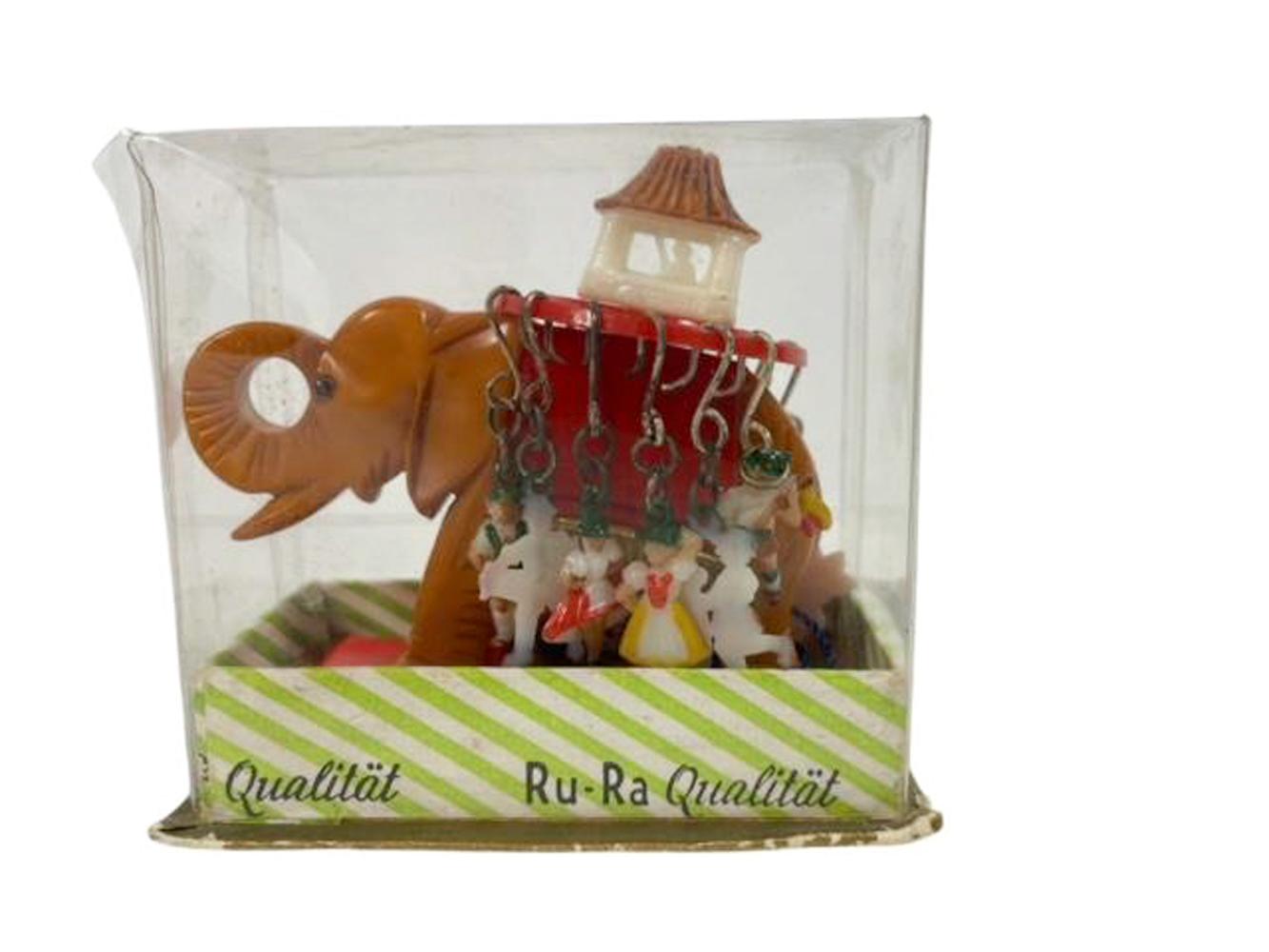 Juego de marcadores de bebida de baquelita de Alemania Occidental en forma de elefante caparazonado con 12 marcadores distintos colgados de la silla en su embalaje original y con etiqueta original. Fabricado por Ru-Ra Qualitat. 