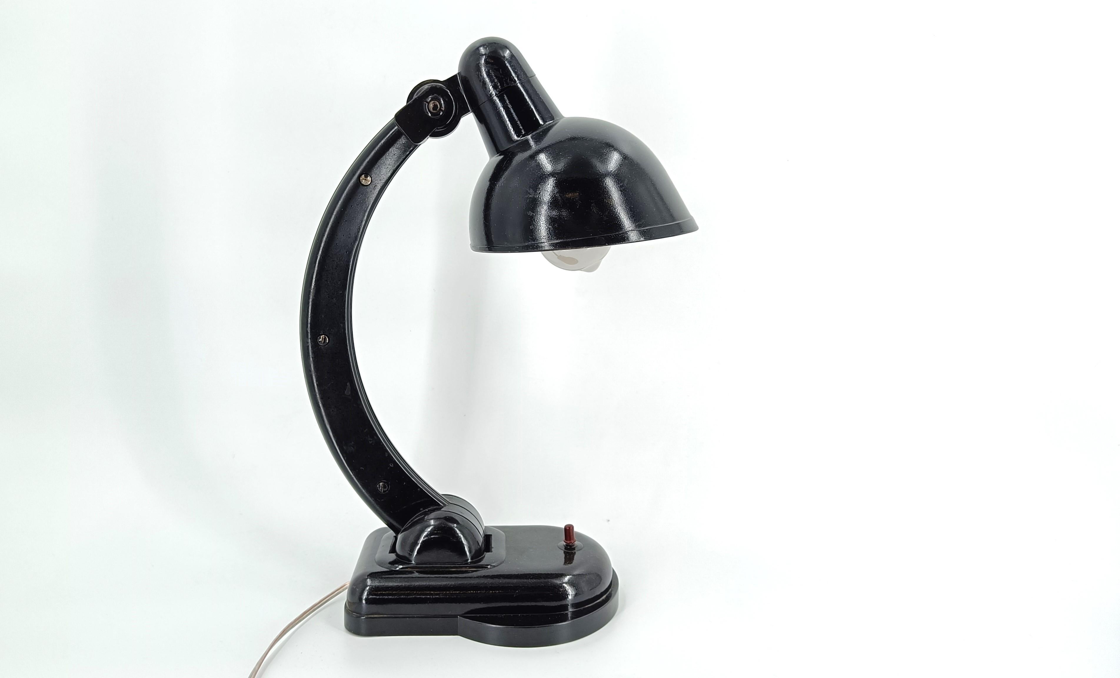 Very stylish bakelite bauhaus style desk lamp which was produced  in the Czech Republic.

The arm and lamp shade can be adjusted which makes this lamp very versatile. It also has its original switch.

Tested and ready to be used with a regular E27