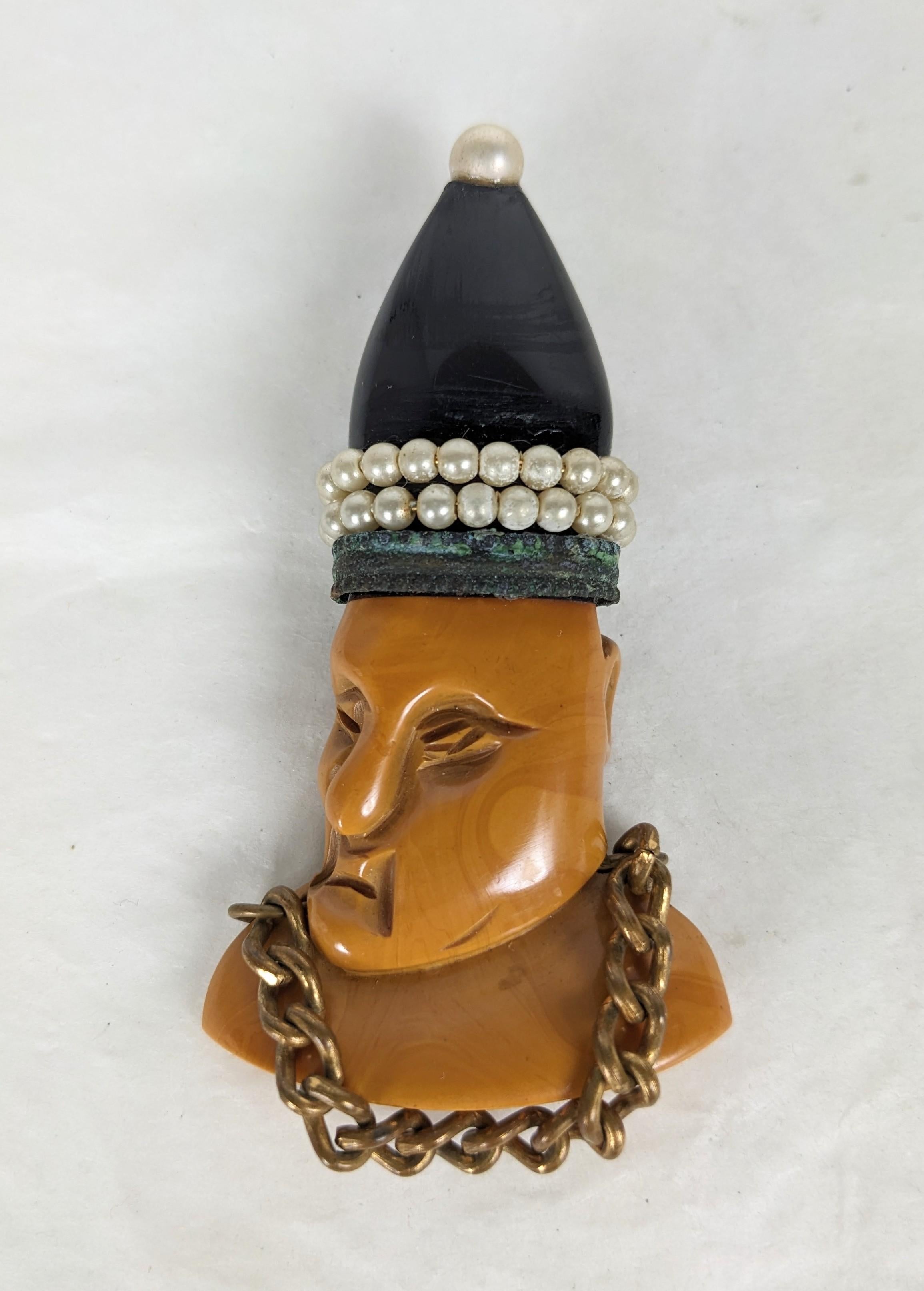Unusual Art Deco Bakelite Figural Papal Brooch from the 1930's. Hand carved of butterscotch and black bakelite with faux pearls and chain detailing. Clip back fittings. 2.75