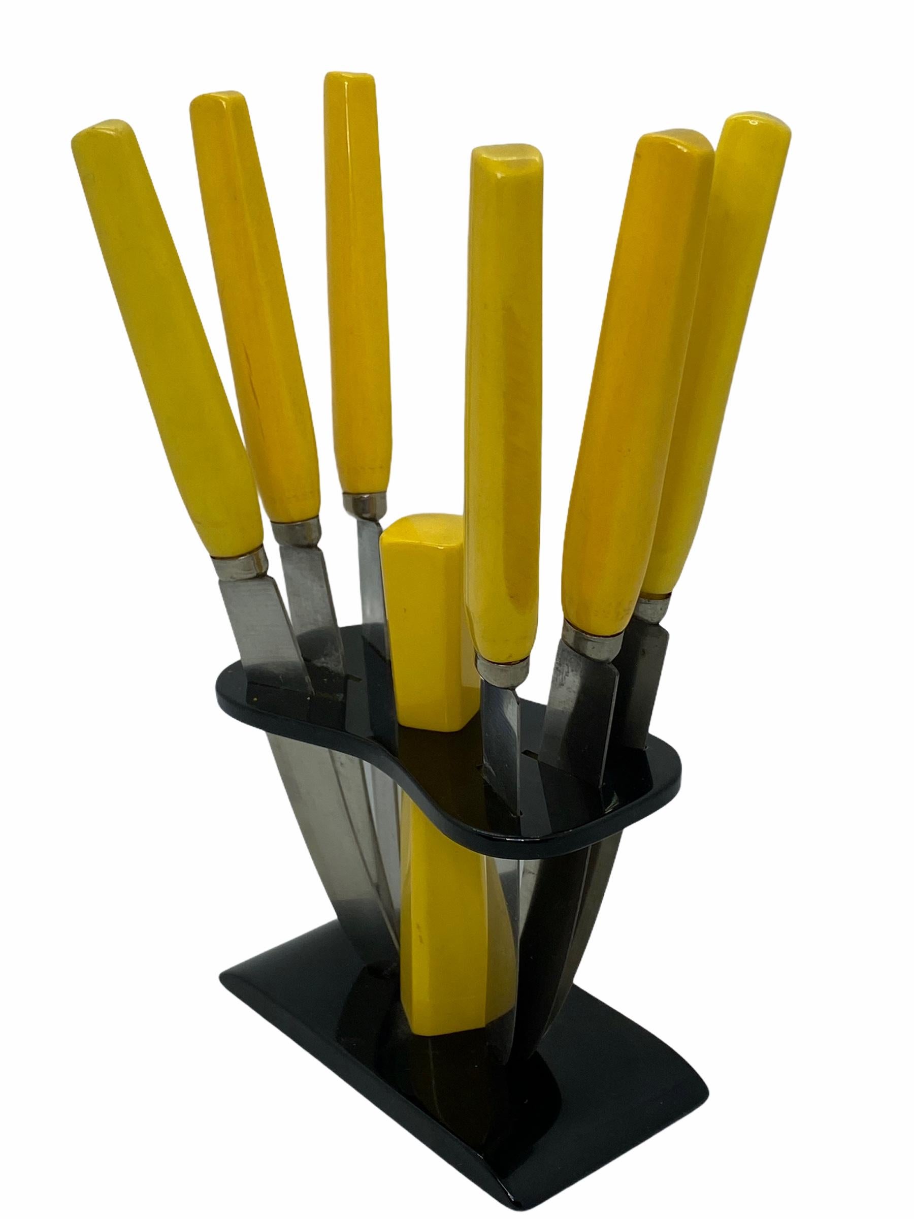 Art Deco Bakelit Obstmesserset aus den 1930er Jahren. Hergestellt in Deutschland. Die Messer mit gelbem Bakelit-Griff sind in einem Bakelit-Ständer untergebracht, der sich hervorragend zur Schau stellen lässt. Ausgezeichneter Zustand. 1930's.
 