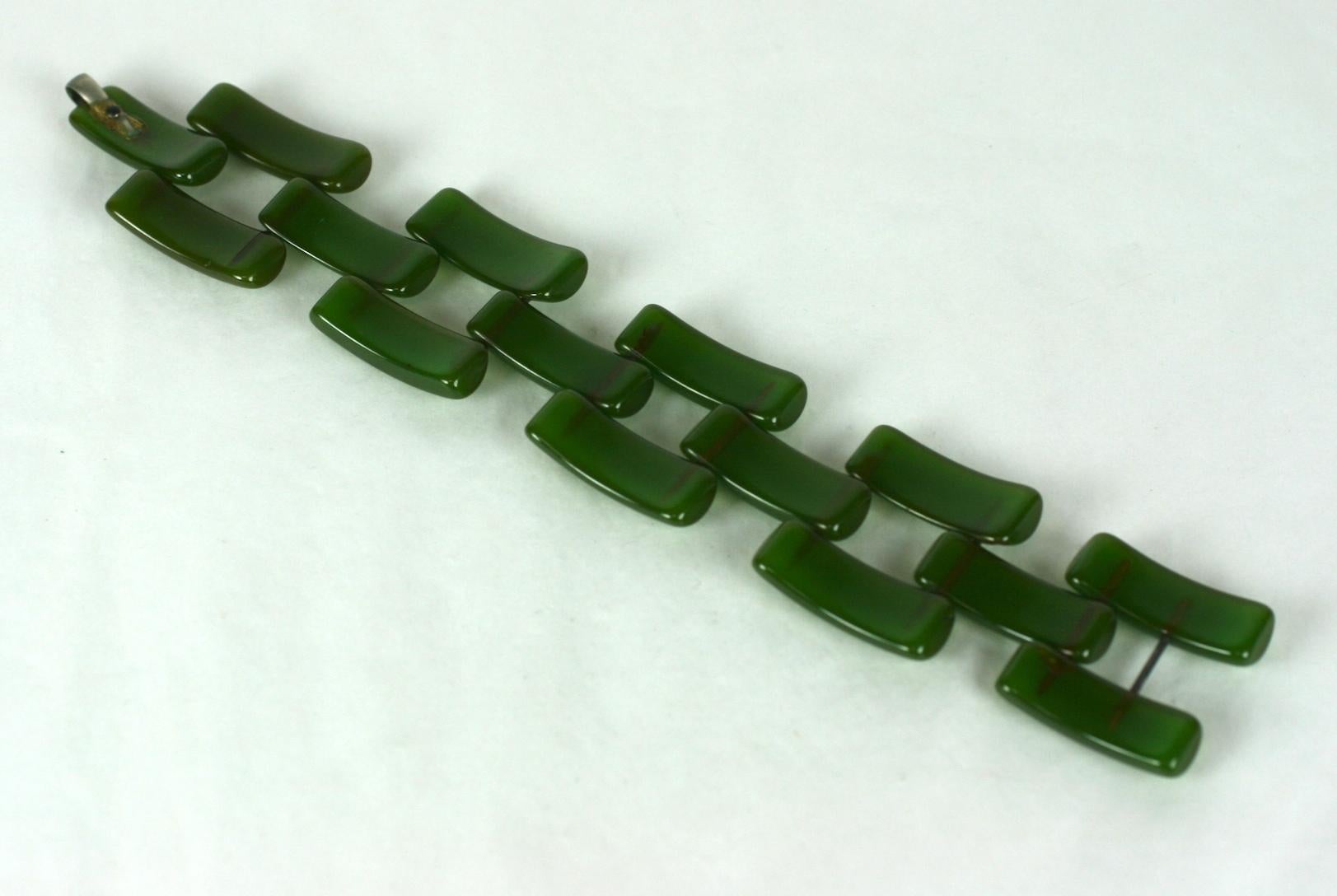 Art Deco Bakelite Link Bracelet in jade green. Curved strips of carved bakelite are pegged with metal rods to form a tank style
flexible design. Wonderful translucent green coloration.  1930's USA. Self hook closure.
Excellent condition. 8