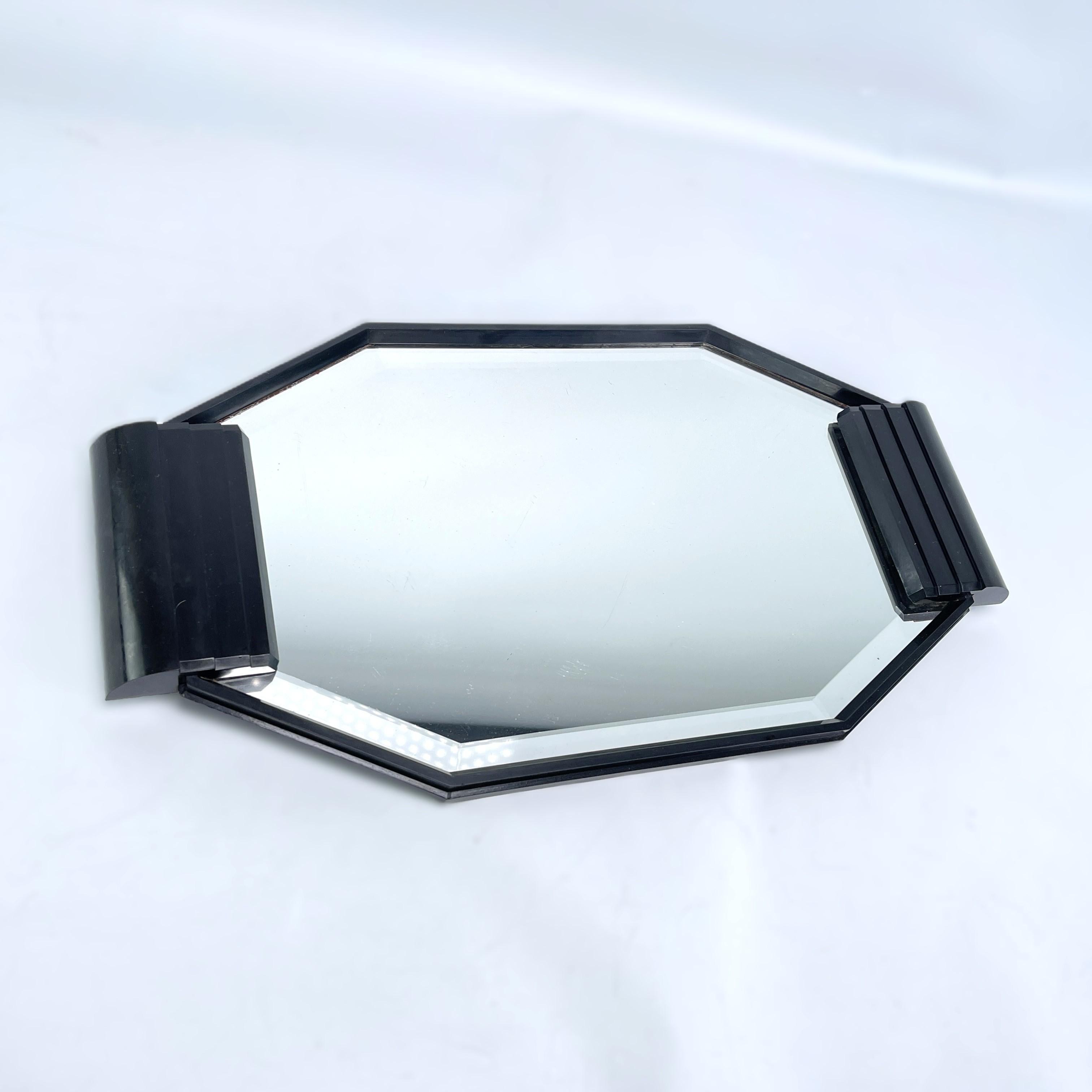 Plateau miroir ART DECO  de bakélite, années 1930

Ce magnifique plateau en bakélite des années 1920 s'inscrit dans le style Streamline Moderne de l'Art déco. Ce style mettait l'accent sur les formes courbes et aérodynamiques. Le plateau