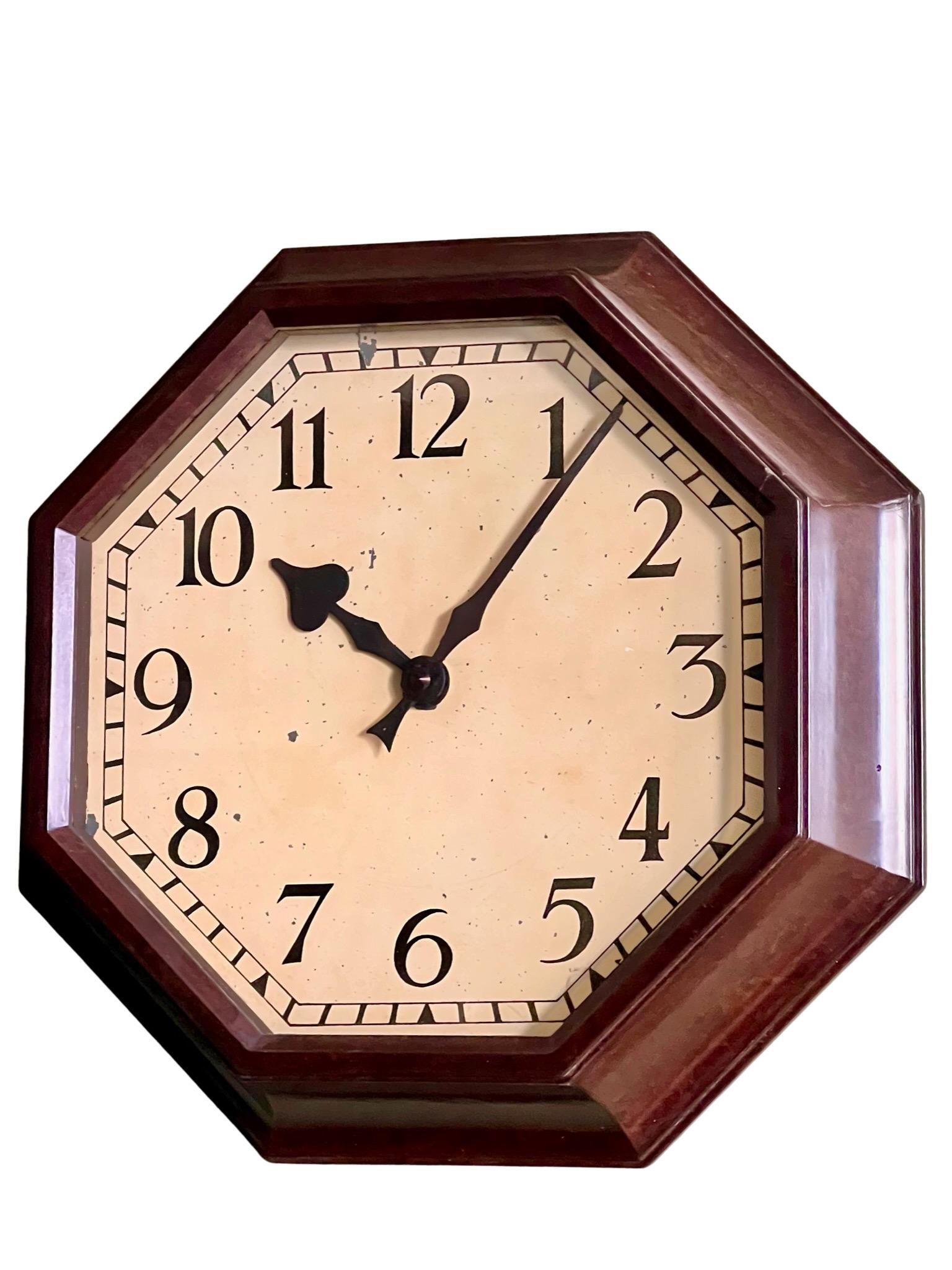Stylish Art Deco bakelite octagonal moulded wall clock with rear brass hanging bracket, white painted dial with Gothic Arabic dial and black spade hands.

This is a stunning piece of vintage design that captures the essence of the Art Deco