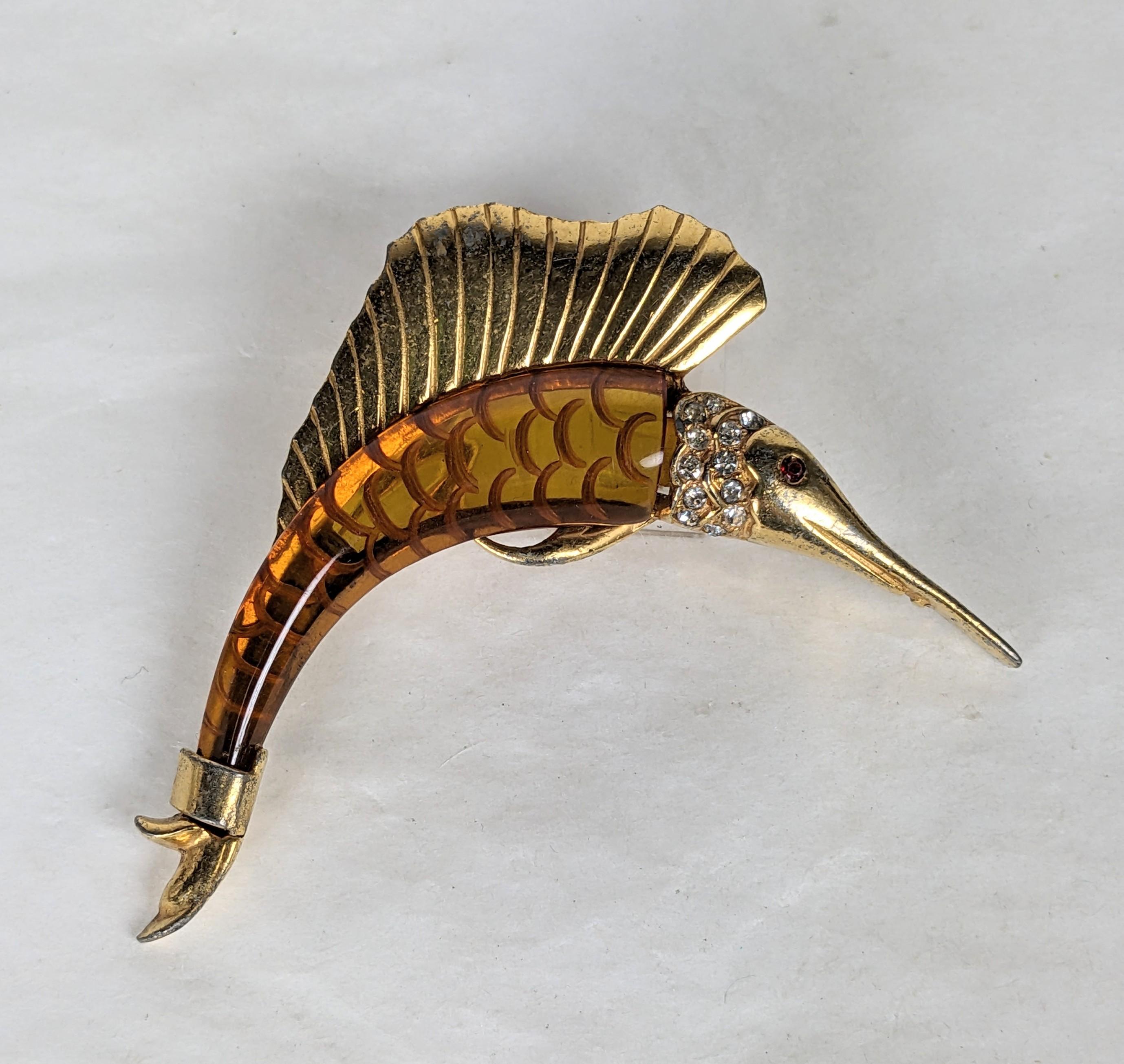 Unusual Art Deco Bakelite Sailfish Brooch of gilt metal with pave accents. Body of fish is reverse carved applejuice bakelite in an amber tone. 1930's USA. 2.75