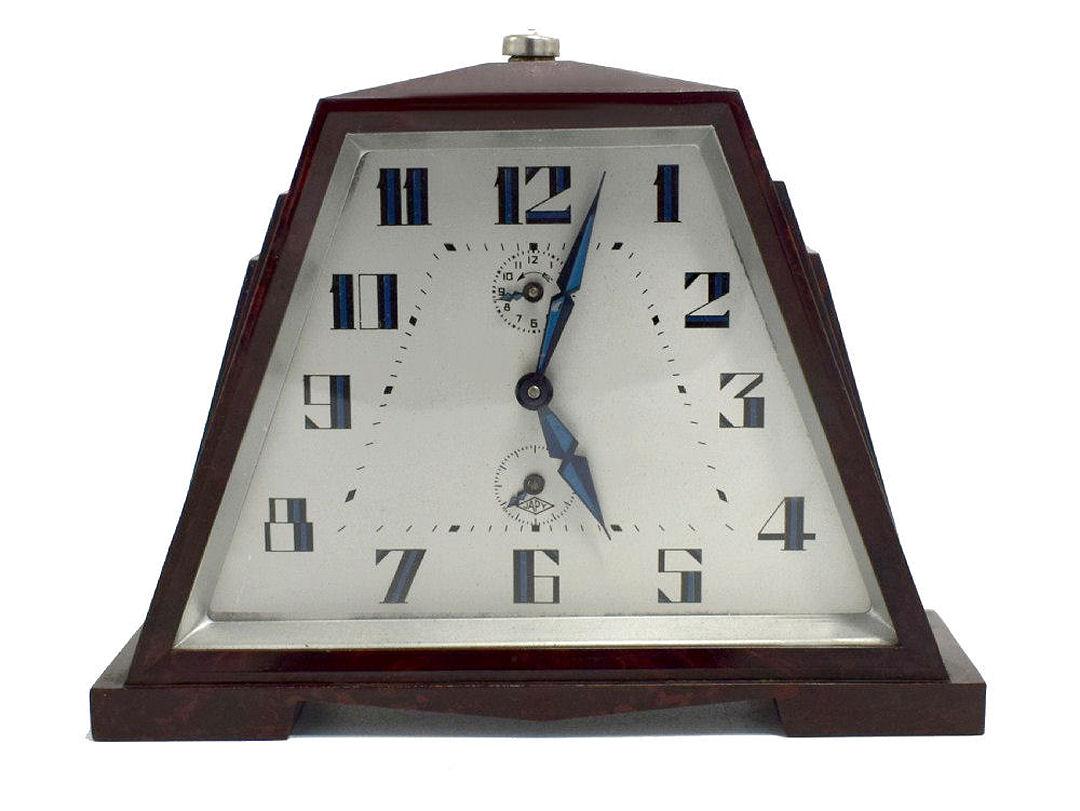 Superb iconic design comes by way of this Art Deco bakelite alarm clock by the French clock makers Japy. Very desirable and rare model bakelite casing with stepped fins to the sides. The dial is an off-white coloring with blue highly styled numerals
