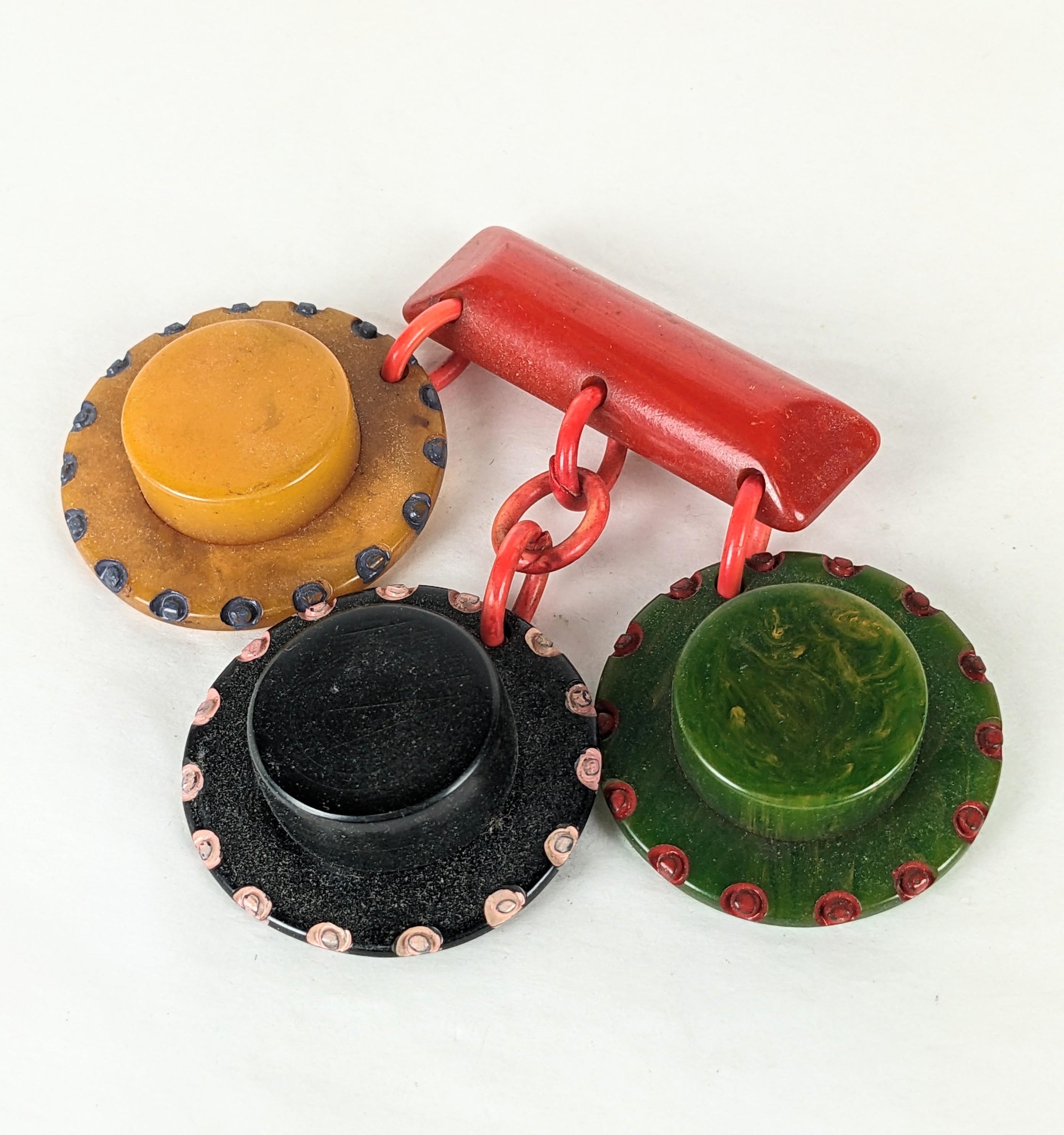 Charming Art Deco Bakelite Brooch of brightly colored carved and painted sombreros dangling from a central red bakelite bar pin. Hat is mango, black and marbled green bakelite.
1930's Collectible US Folk Art. 3.25