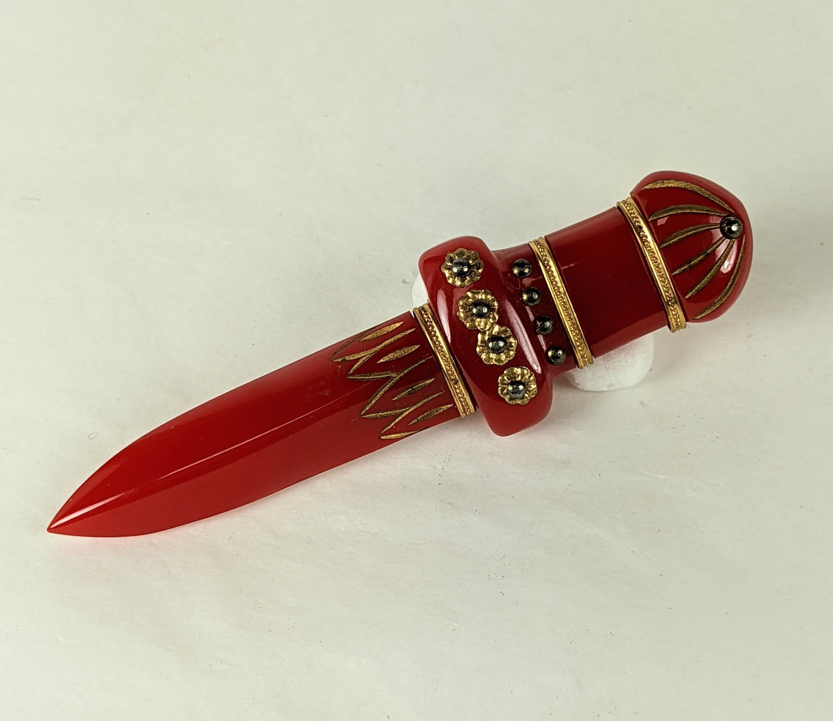 Large Art Deco Bakelite Sword Brooch from the 1930's. Hand carved with gilt filigree decoration and nail heads. Incised areas have gilt enamel decoration.  
4