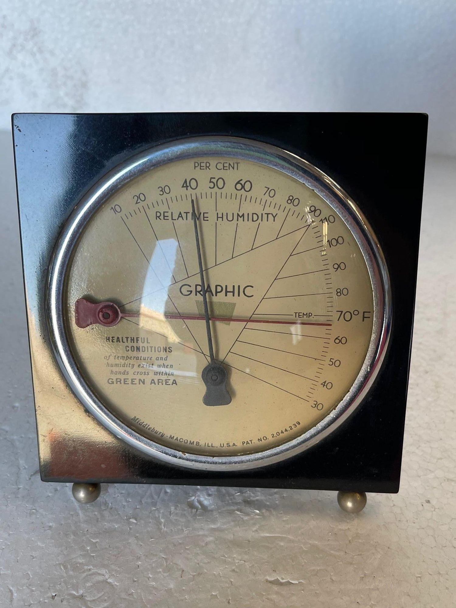 Streamline Art Deco temperature & humidity monitor weather station by Middlebury. This weather station features a brown Bakelite body with a rounded bubble glass face shielding 2 needles one measuring temperature and the other measuring