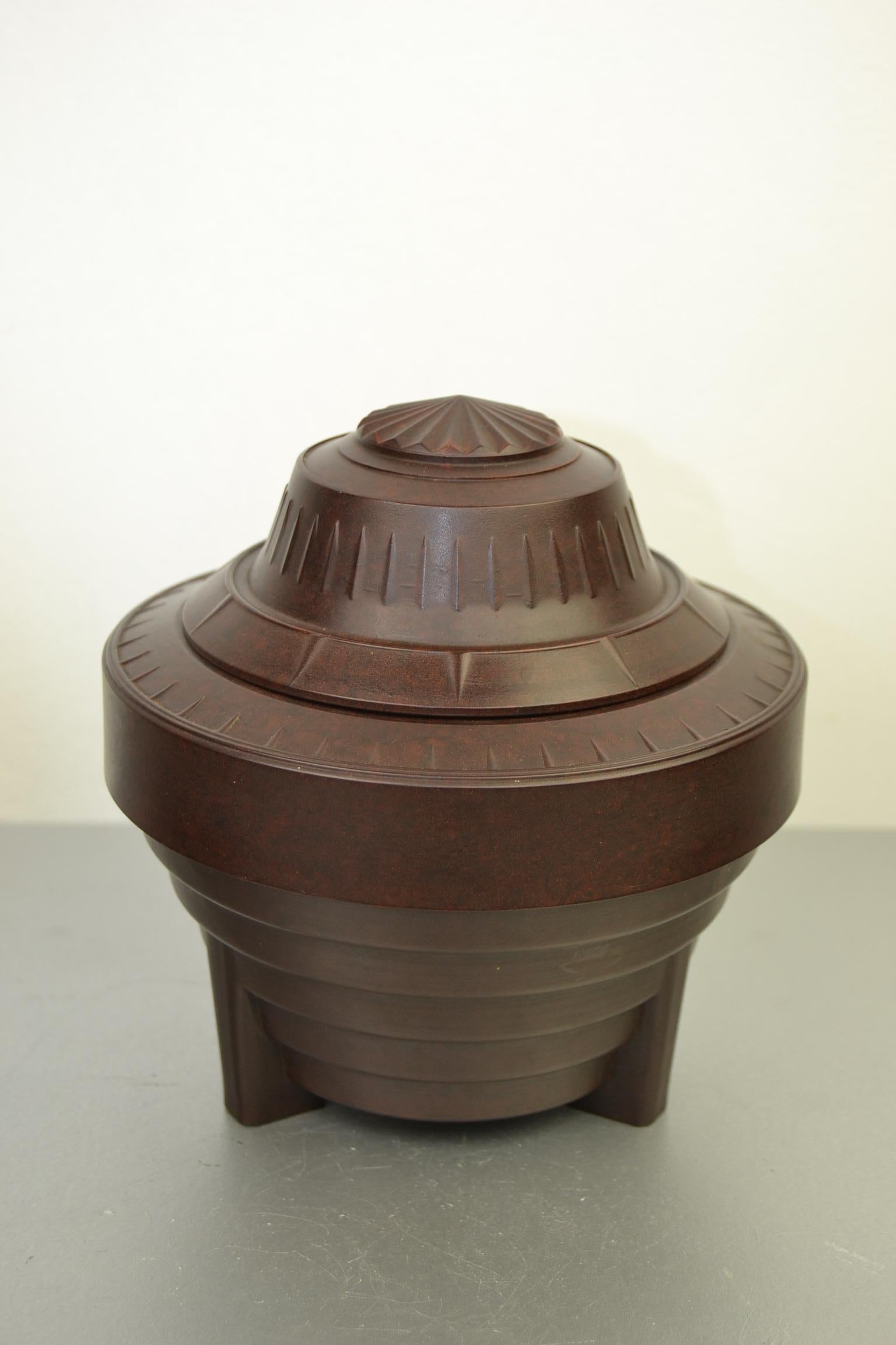 Art Deco Bakelite tobacco Jar - Tobacco box. 
This Bakelite decorative box has a great design and shape : 
looks UFO shaped - space style - an UFO on legs ready to take off.

This brown bakelite box from the 1920s-1930s has a lid wich can be