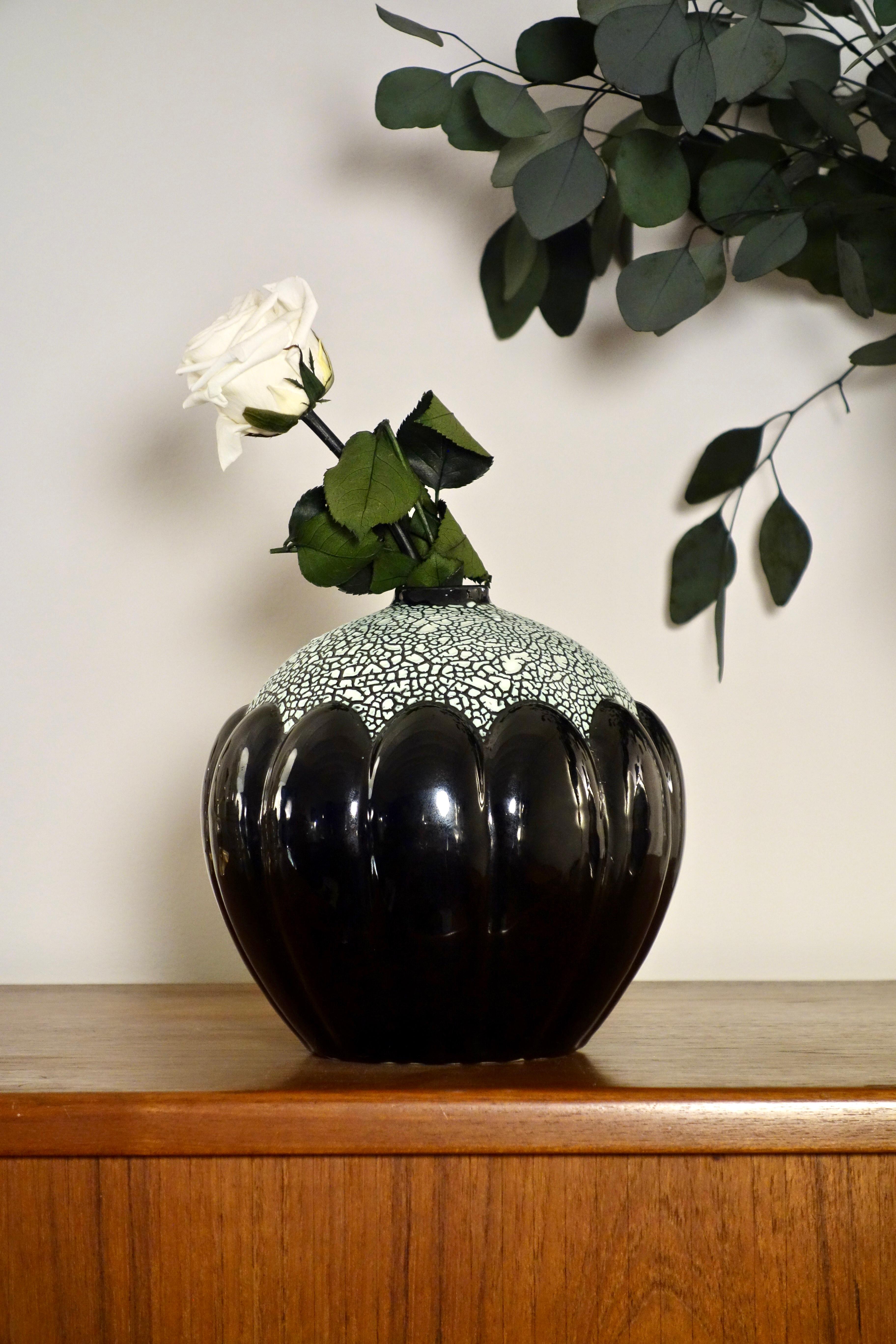 Vase Soliflores Art Déco signé par la manufacture Saint Clément

Datant des années 1930, cet objet raffiné aux lignes géométriques apportait une touche élégante et intemporelle à votre intérieur.

En faïence émaillée noir irisé avec son corps en