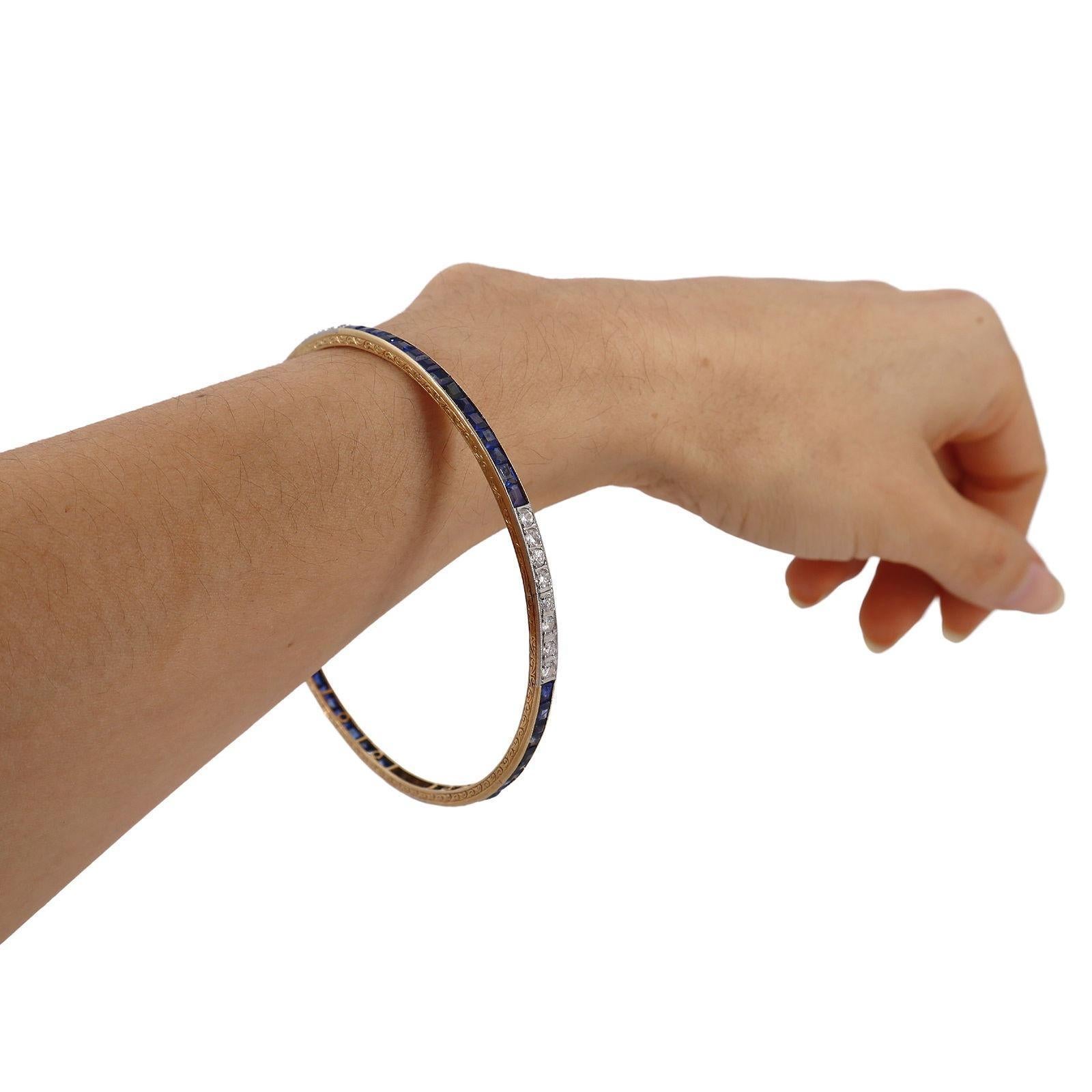 A striking example of early Art Deco design, this wide bangle bracelet (circa 1910–1920s) is expertly crafted in 18kt yellow and white gold. The bracelet is accented with 60 vibrant blue sapphires totaling approximately 5.00 carats, creating a