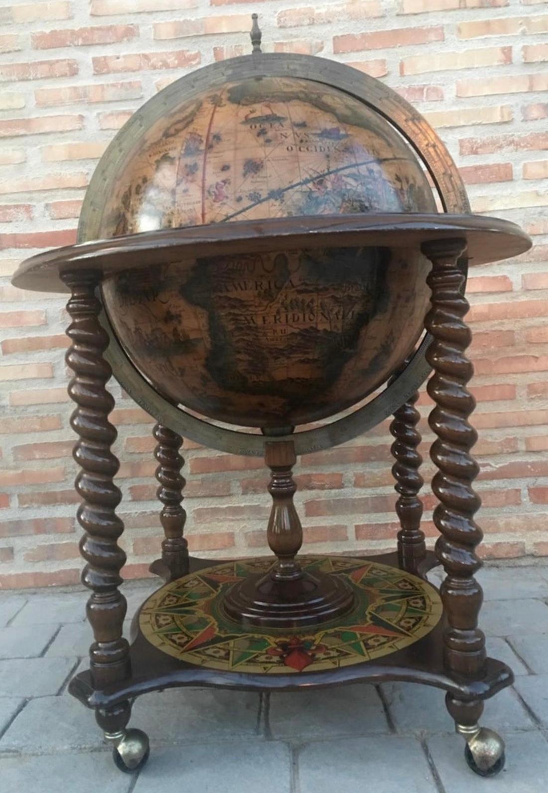 This is a modernist midcentury cocktail drinks cabinet in the form of a globe, circa 1940 in date. The hinged top section opens to reveal a fitted interior with spaces for glasses and a ice bucket. The exterior of the globe has the map of the world.