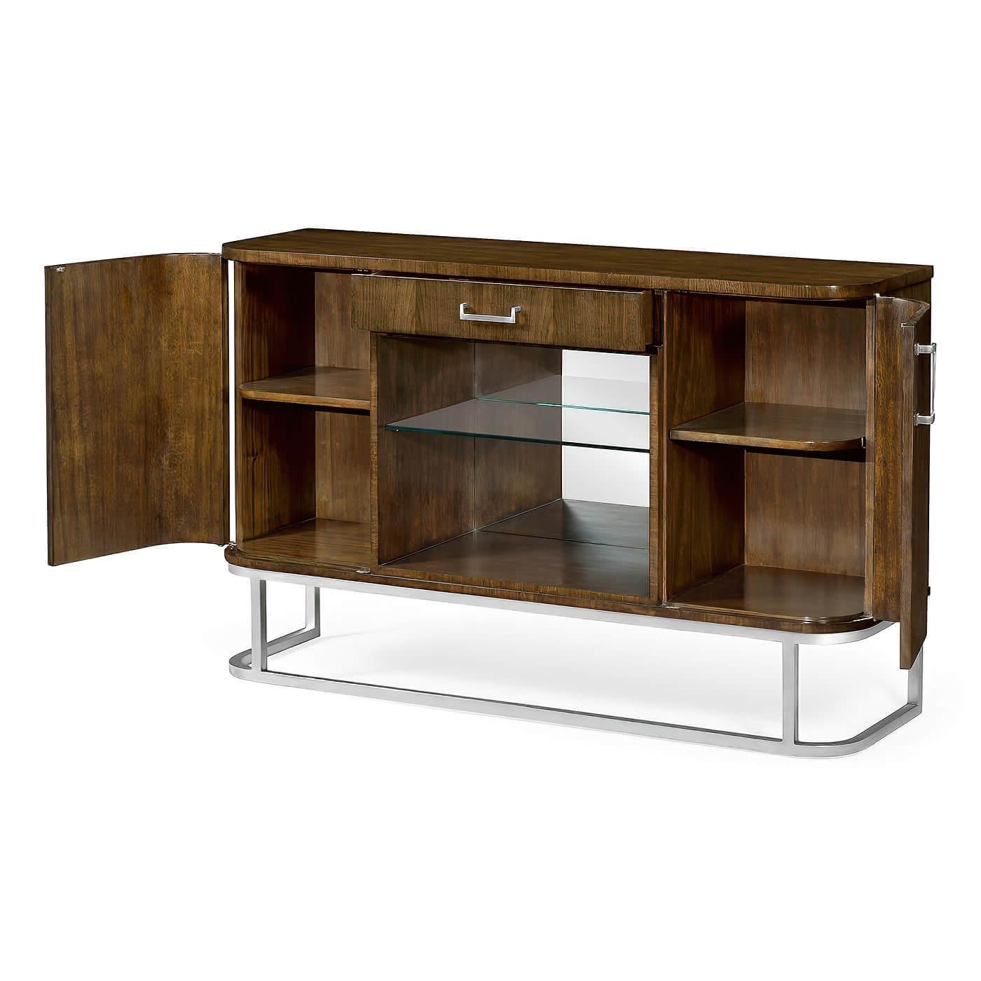 An Art Deco style two-door drinks buffet cabinet in American walnut with a single shelf in clear glass and a drawer with stainless steel handles. Interior design features two single cupboards with a single shelf in silver-leaf and stainless steel