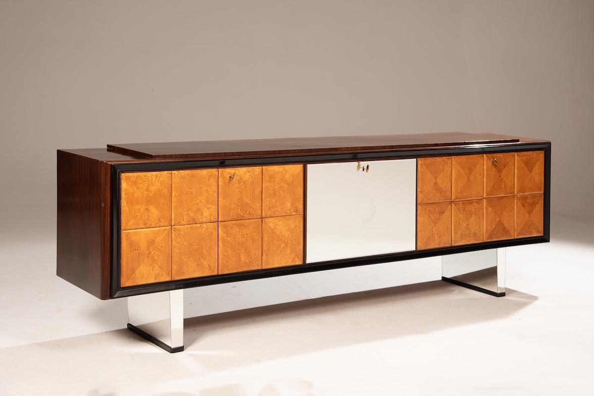 Credenza/armadio bar Art Déco in radica di olmo e palissandro. Il pezzo può fungere anche da bar, grazie a un'anta centrale a specchio che nasconde un interno circolare a mosaico a specchio. Le porte in legno sono caratterizzate da pannelli a