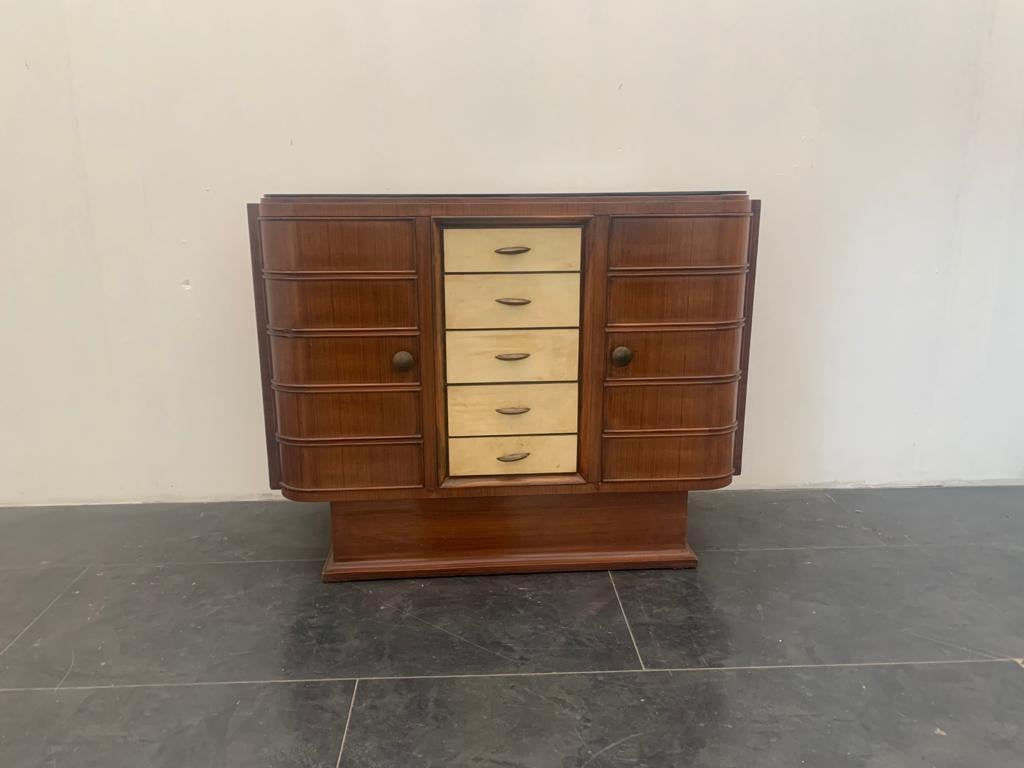 Art Deco Bar Cabinet in Rosewood and Parchment with Top in Black Glass.
In the style of Osvaldo Borsani (I have official proof of authenticity, such as period catalogs, design documents, or other literary sources). 
Packaging with bubble wrap and