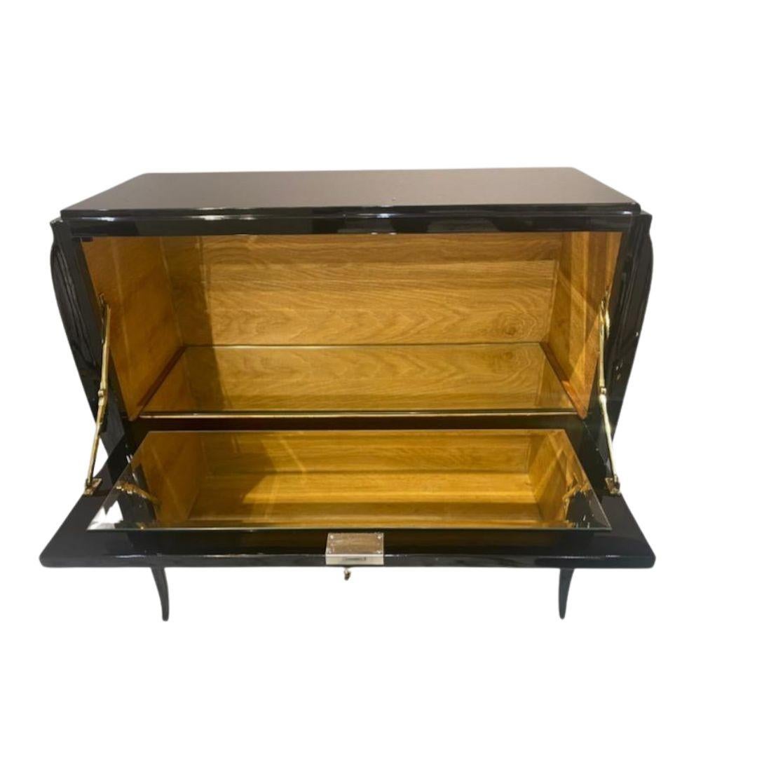 Questo raffinato mobile bar originale di Jean Pascaud (1891-1945) riflette la raffinata eleganza del design francese della metà del XX secolo. Realizzato con una finitura laccata nera lucida, l'estetica elegante e minimalista del mobile è