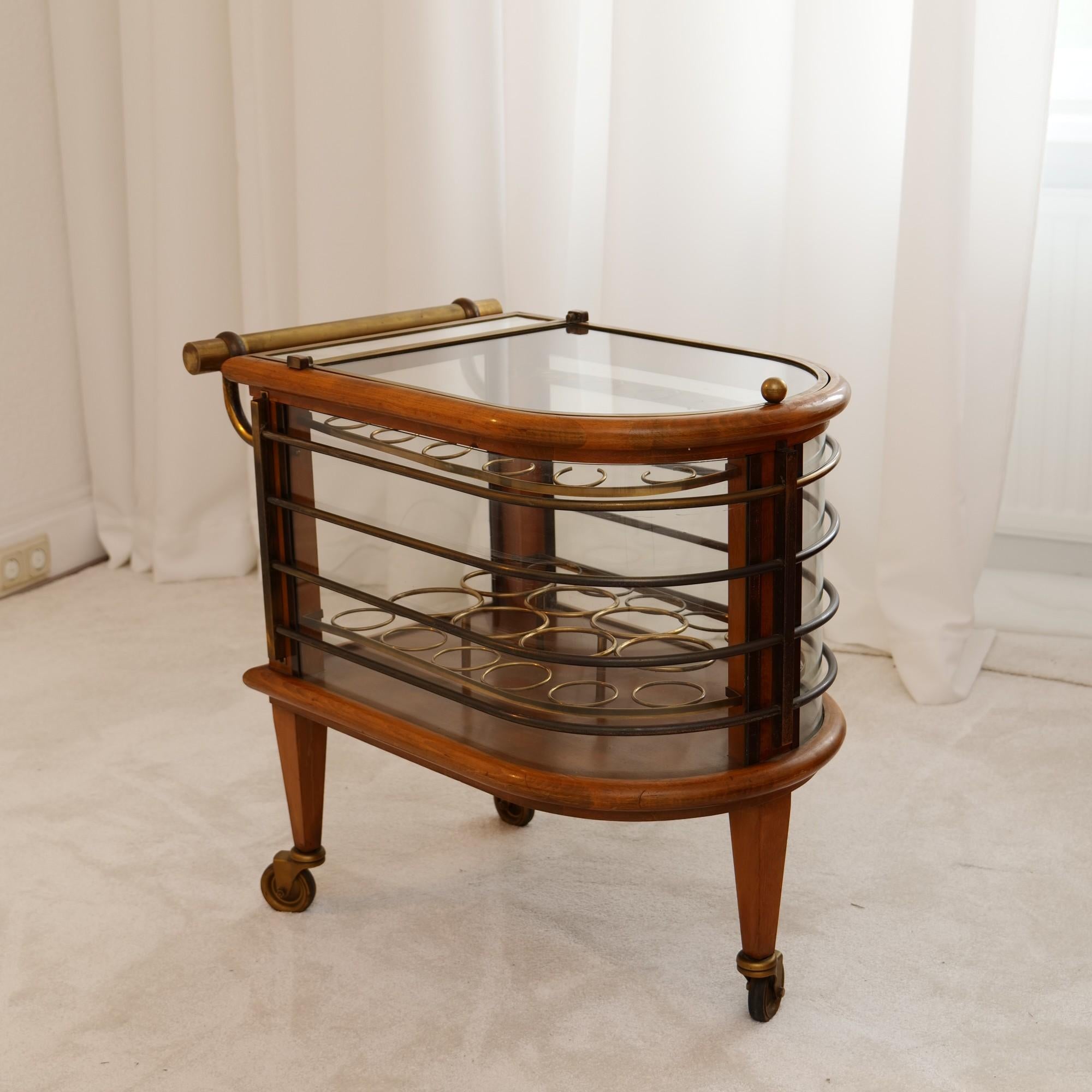 - rare art deco streamline bar cart
- 1940s french by Louis Sognot
- handcrafted by french artisans 
- made of curved glass and wood, brass and mirror
- original and untouched condition
- beautiful patina

72 cm x 60 cm x 42 cm
102 cm depth when