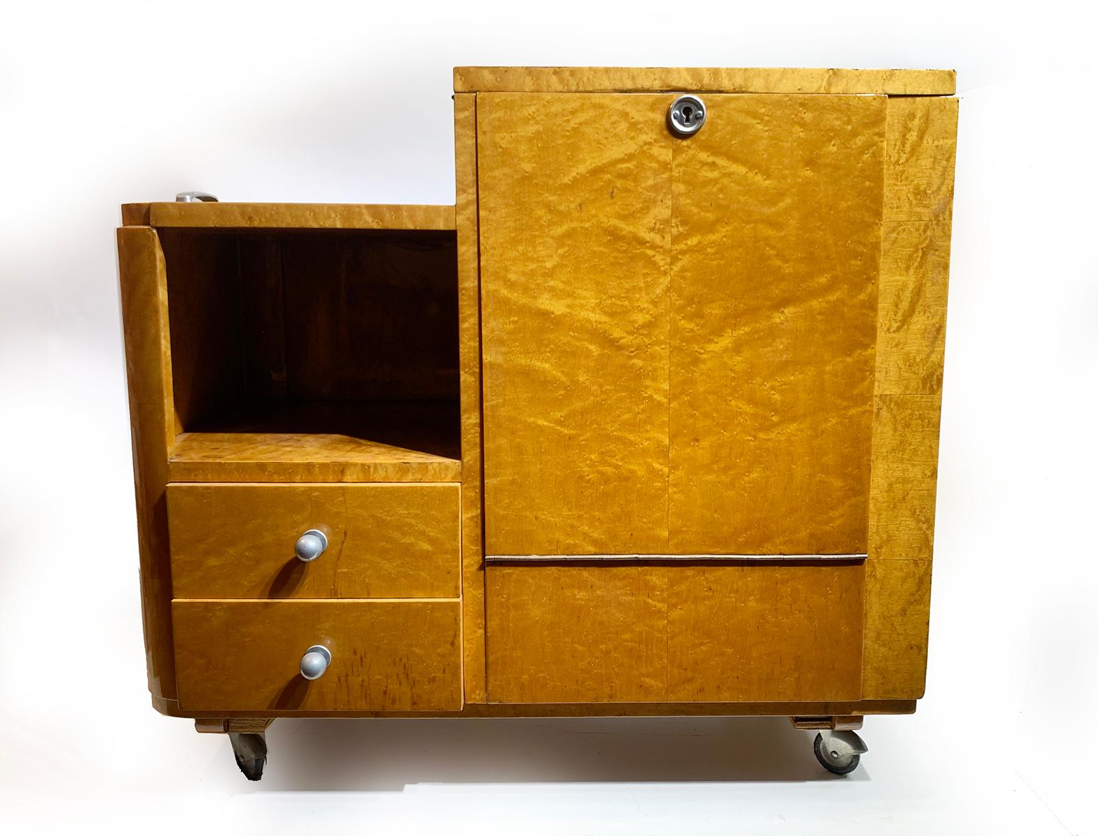 A French Mid-century Art Deco bar cart having a storage cabinet , two drawers and four rubber wheels with beautiful veneer, circa 1940s