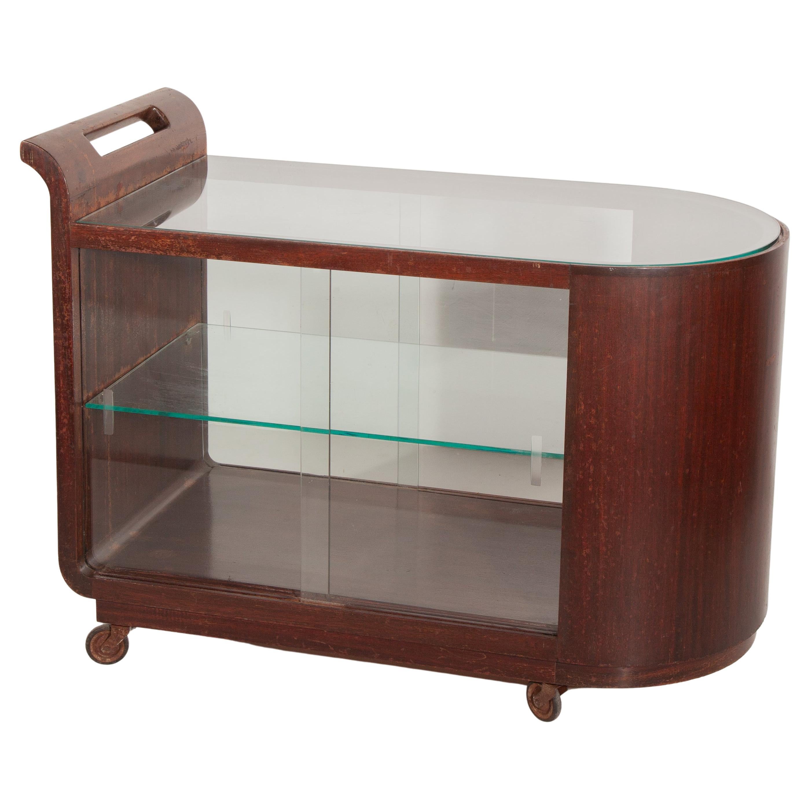 Original Art Deco Bar Cart, Trolley en bois massif avec placage de noyer capture avec ses formes rondes et un dessus en verre conçu par Pander et Zn, années 1920, design hollandais. Le Trolley est en bon état d'origine avec quelques signes